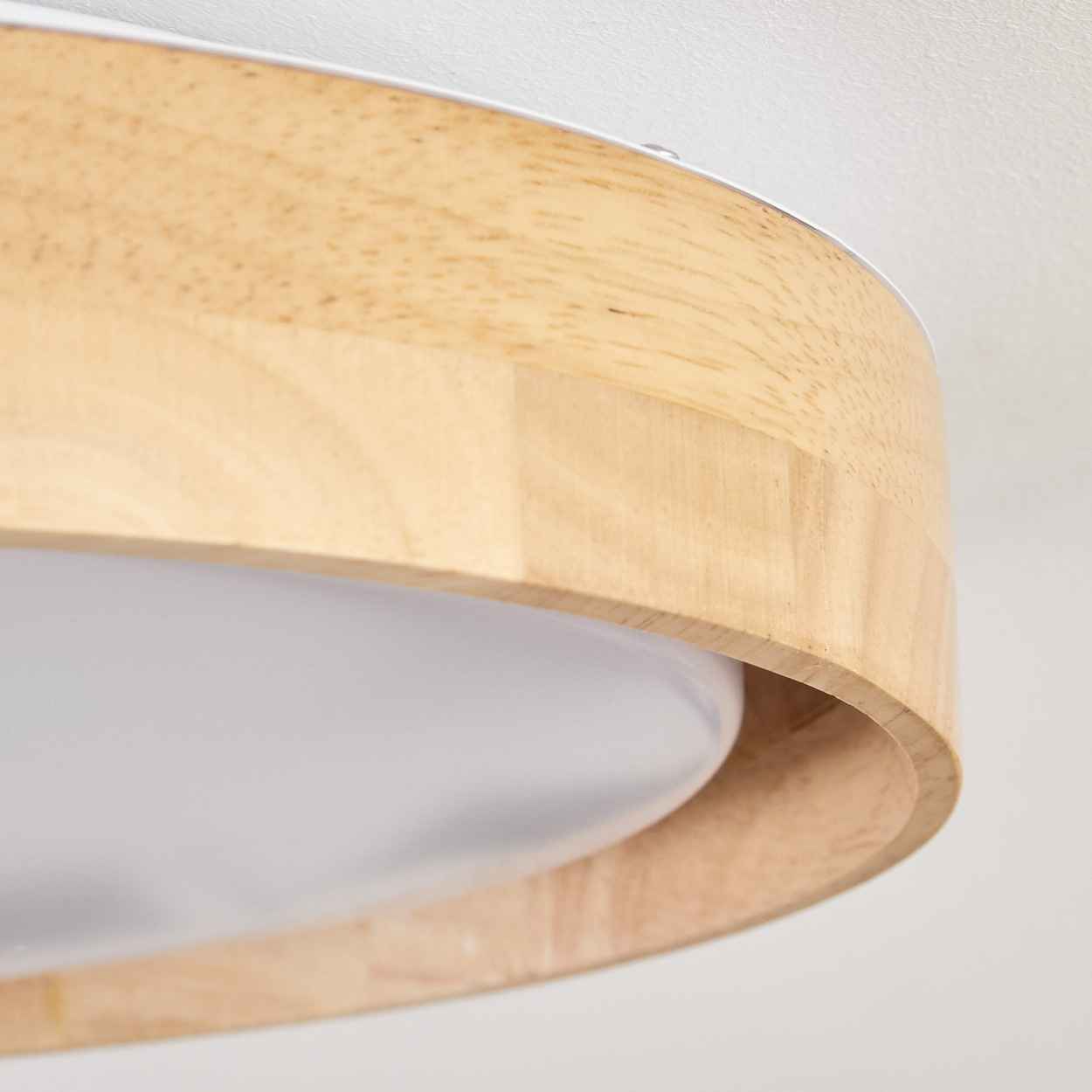 Nahaufnahme einer Deckenlampe aus Holz. Der Rahmen besteht aus Holz und das Licht ist hell und gleichmäßig.