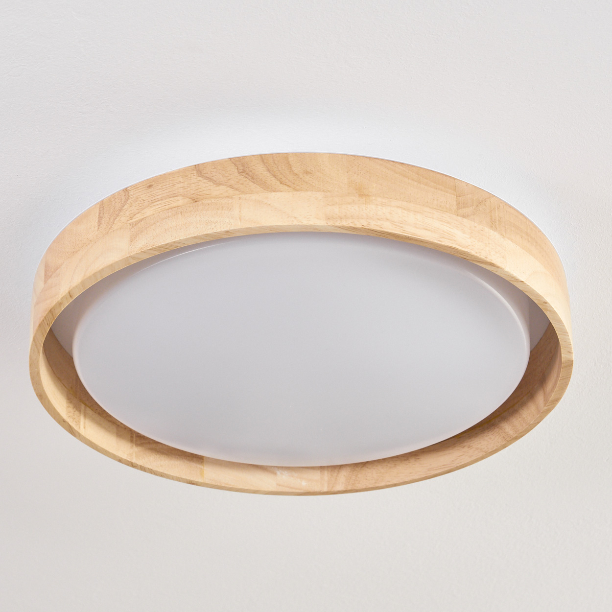 Eine moderne, runde Deckenleuchte mit Holzrahmen und weißem, diffusem Lichtpanel.