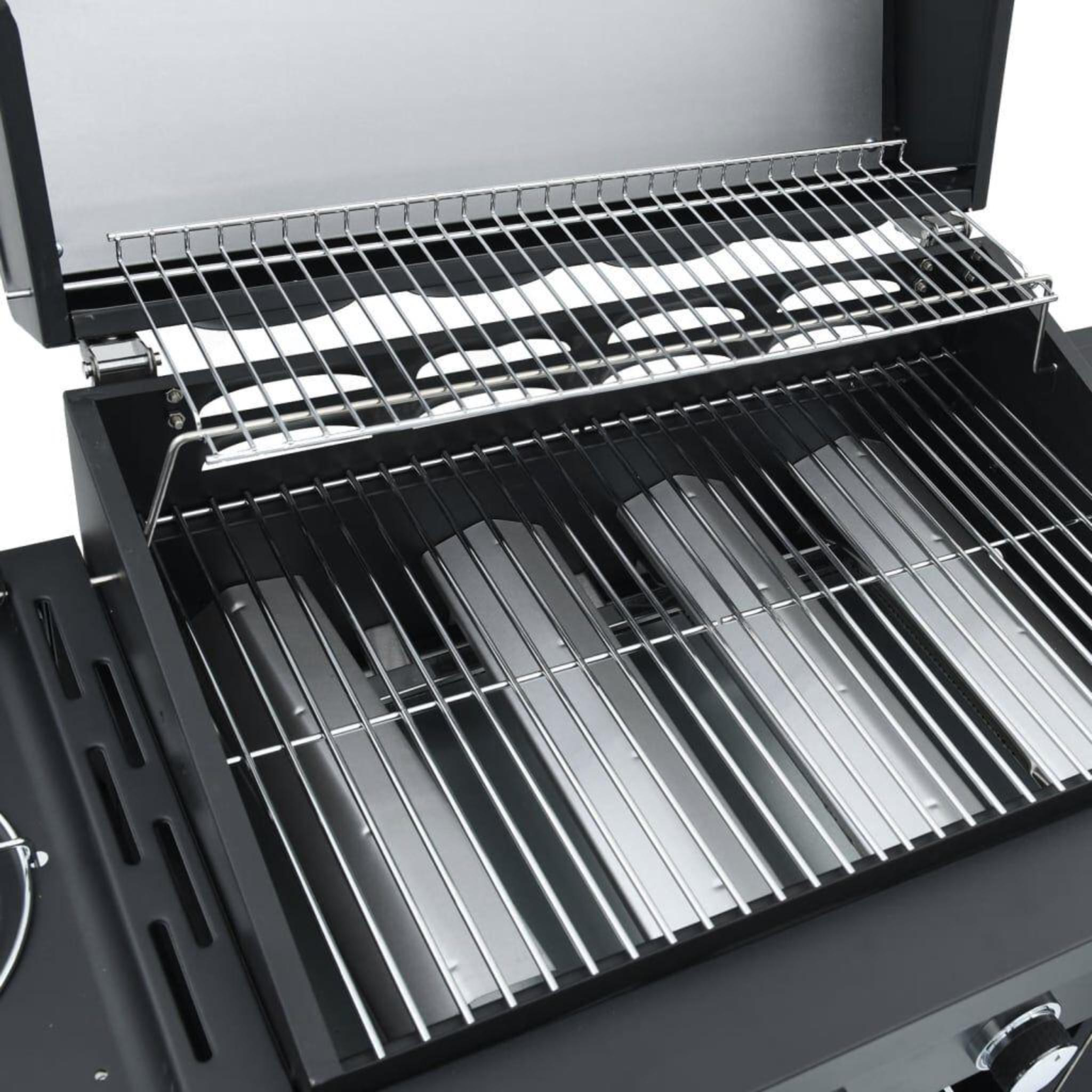 Nahaufnahme des Inneren eines Grills. Edelstahlroste und Flammenbändiger sind in einem schwarzen Grill sichtbar.