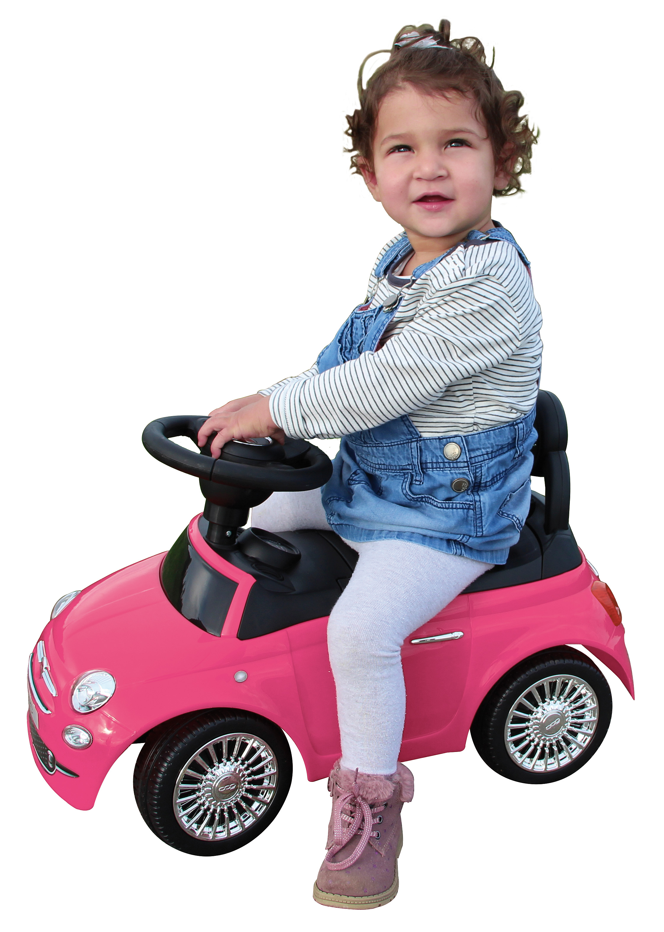 Bambina seduta su un'auto giocattolo rosa. Indossa un vestito di jeans e leggings bianchi.