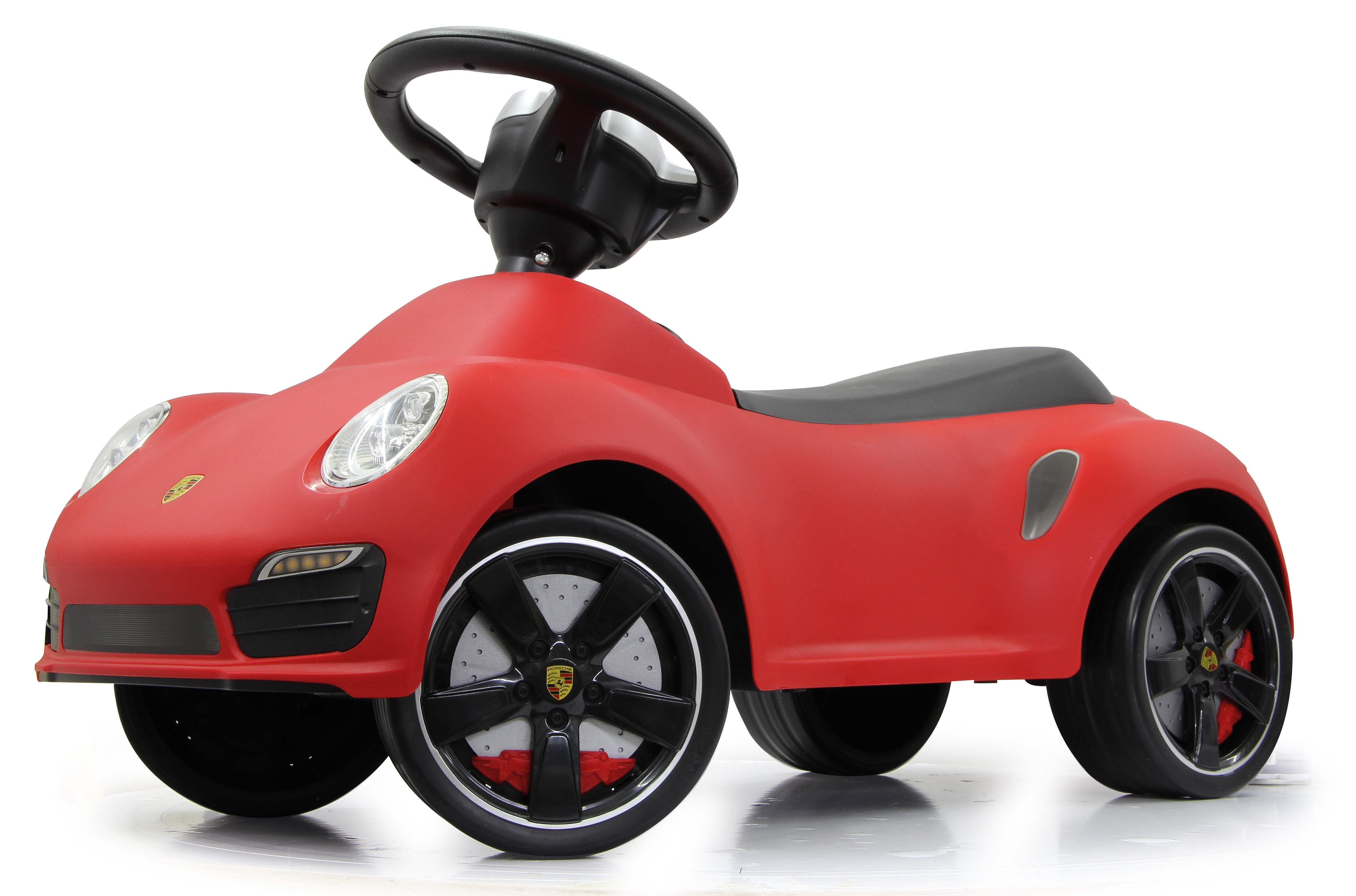Coche de juguete Porsche rojo con ruedas y volante negros, fondo blanco.