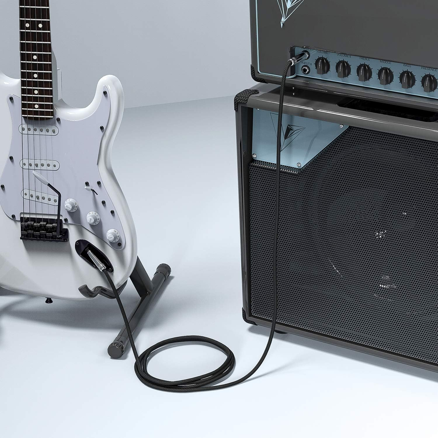 Weiße E-Gitarre und schwarzes Kabel, verbunden mit einem grauen Verstärker.