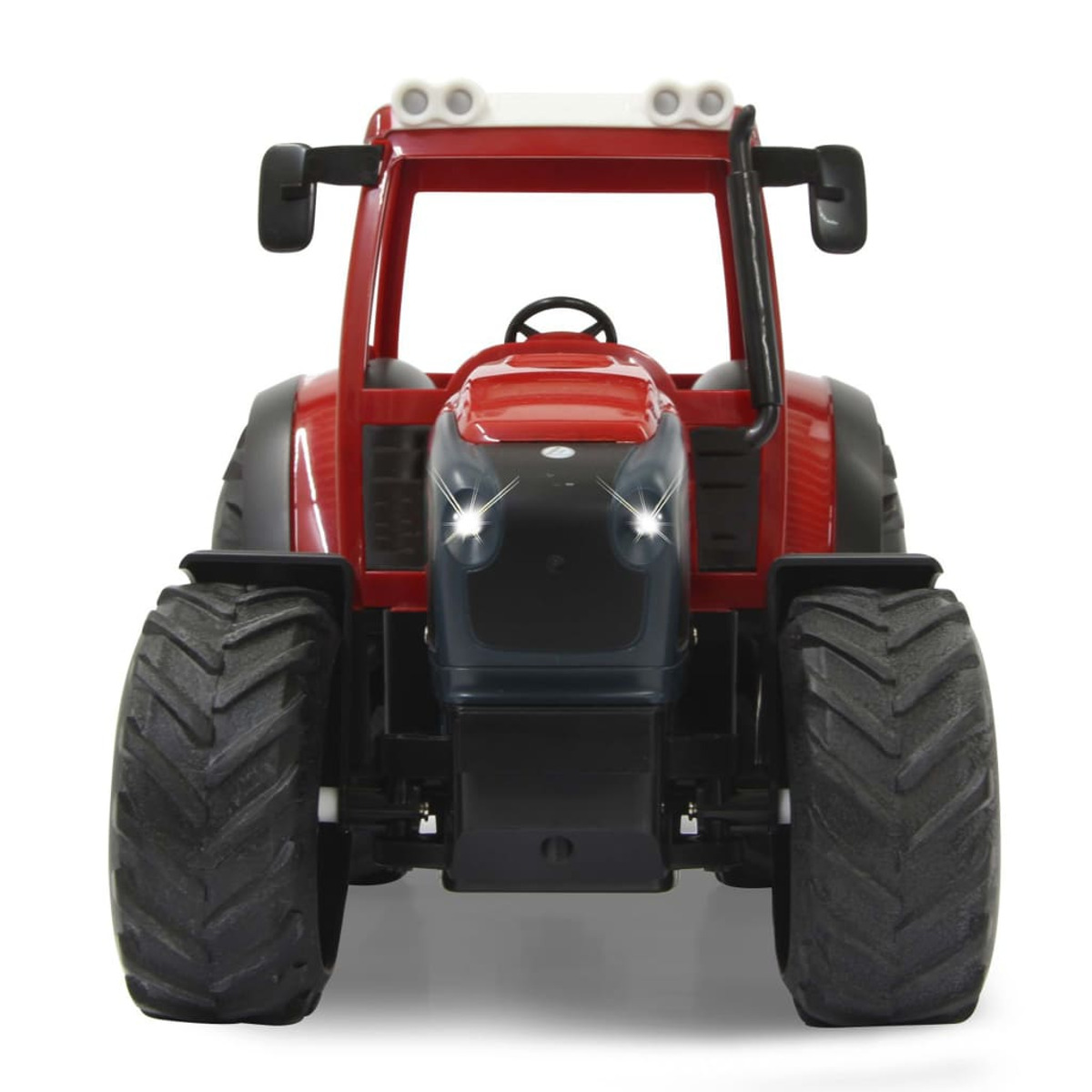 Roter Spielzeugtraktor, schwarze Reifen, weißes Dach, beleuchtete Scheinwerfer, auf weißem Hintergrund.