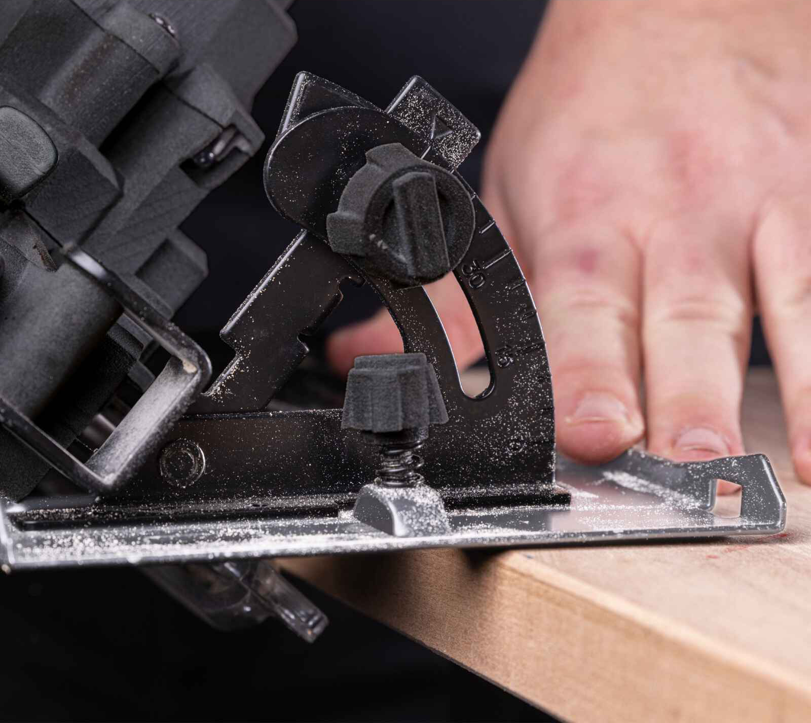 Nahaufnahme einer Kreissäge, die Holz schneidet, der Benutzer bedient sie.