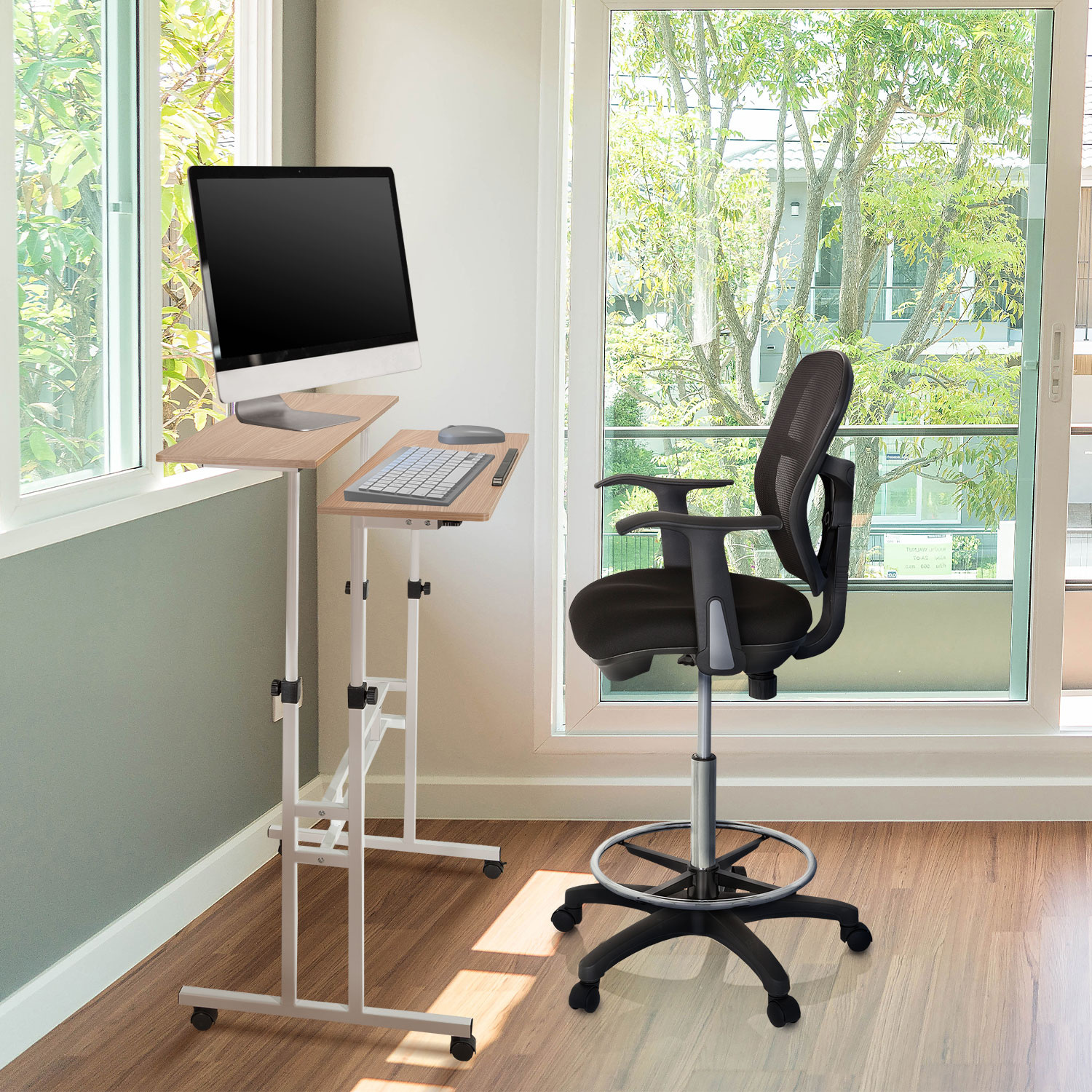 Büro-Setup mit Stehpult und schwarzem Stuhl in Fensternähe mit Außenansicht.