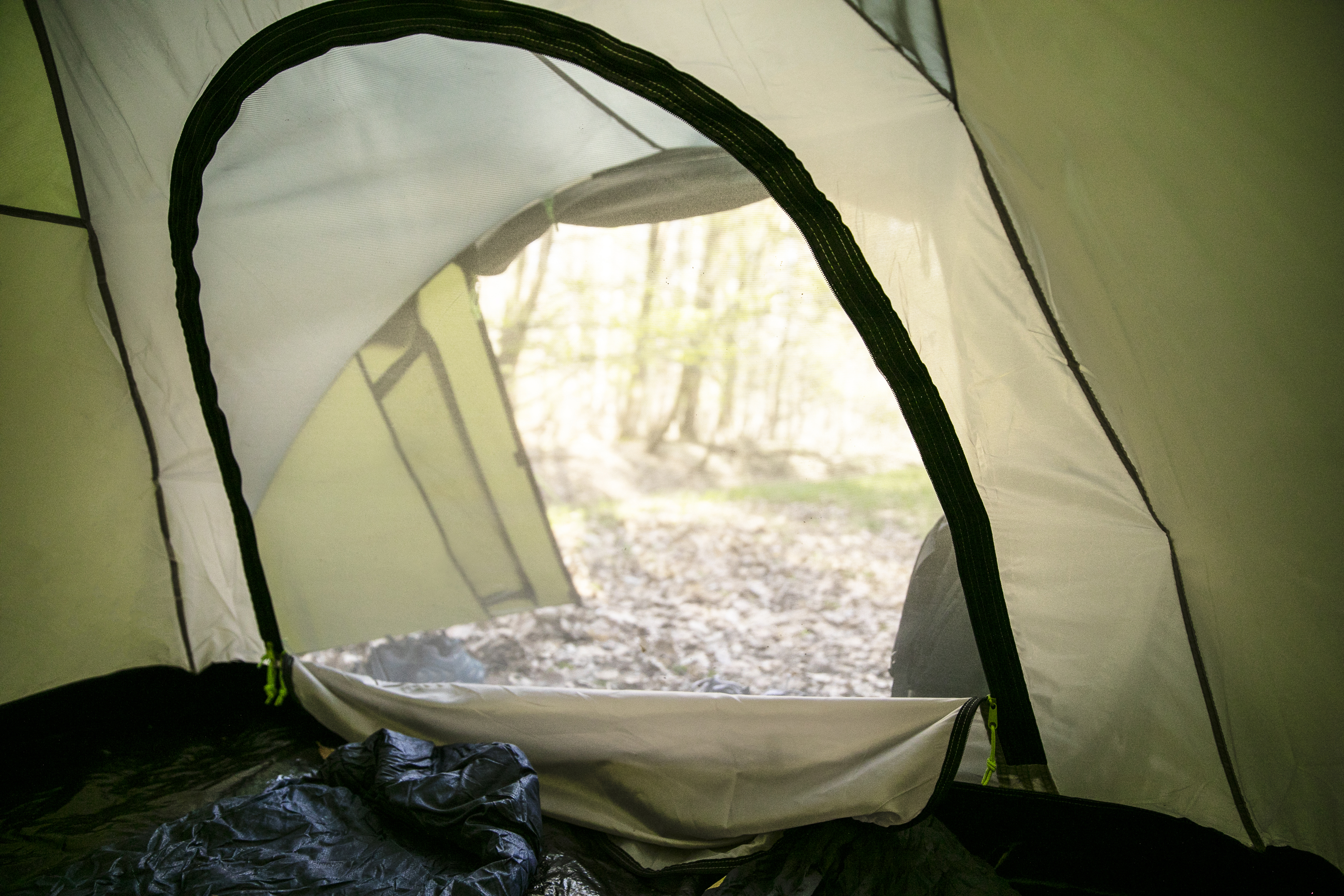 Ansicht des offenen Eingangs eines Zeltes mit verschwommenem Wald.