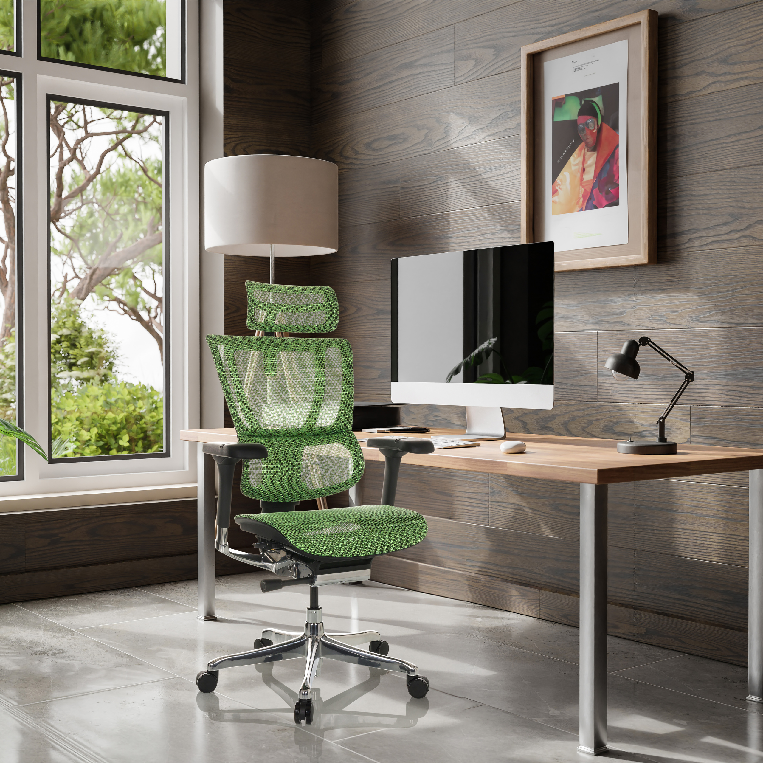 Grüner Netz-Bürostuhl an einem Holzschreibtisch mit Computer, Lampe und Fenster in einem modernen Büro.