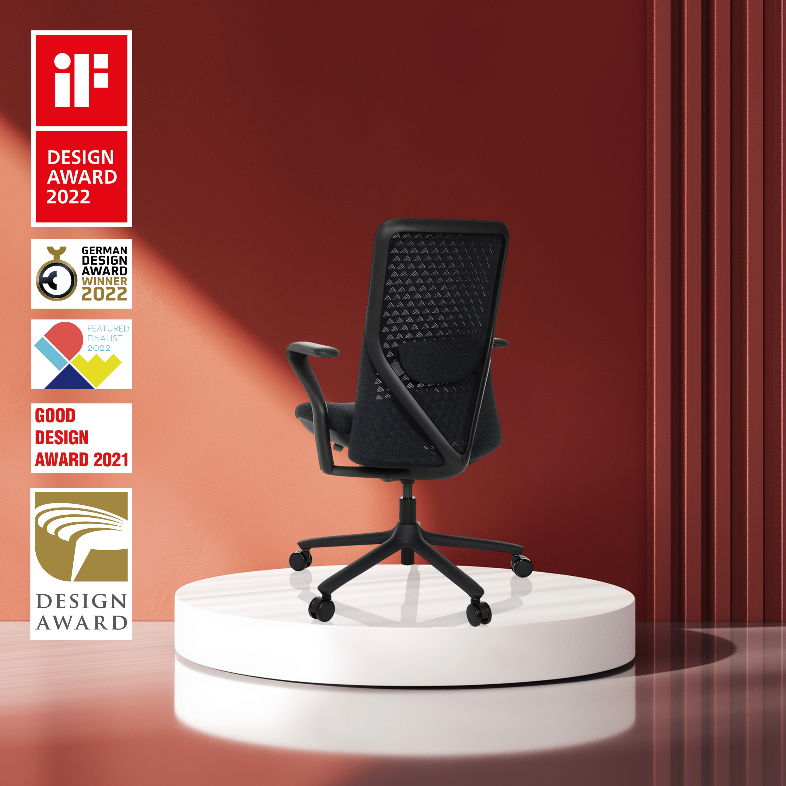Schwarzer Stuhl mit Auszeichnungen auf weißer Plattform. Auszeichnungen umfassen Designpreise.