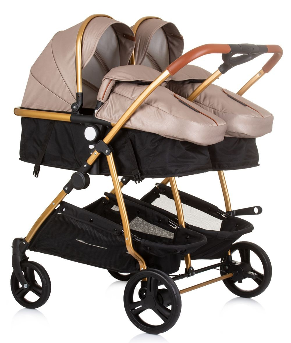 Doppelkinderwagen mit beigefarbenen Verdecken, goldenem Rahmen, schwarzen Aufbewahrungskörben und Rädern.