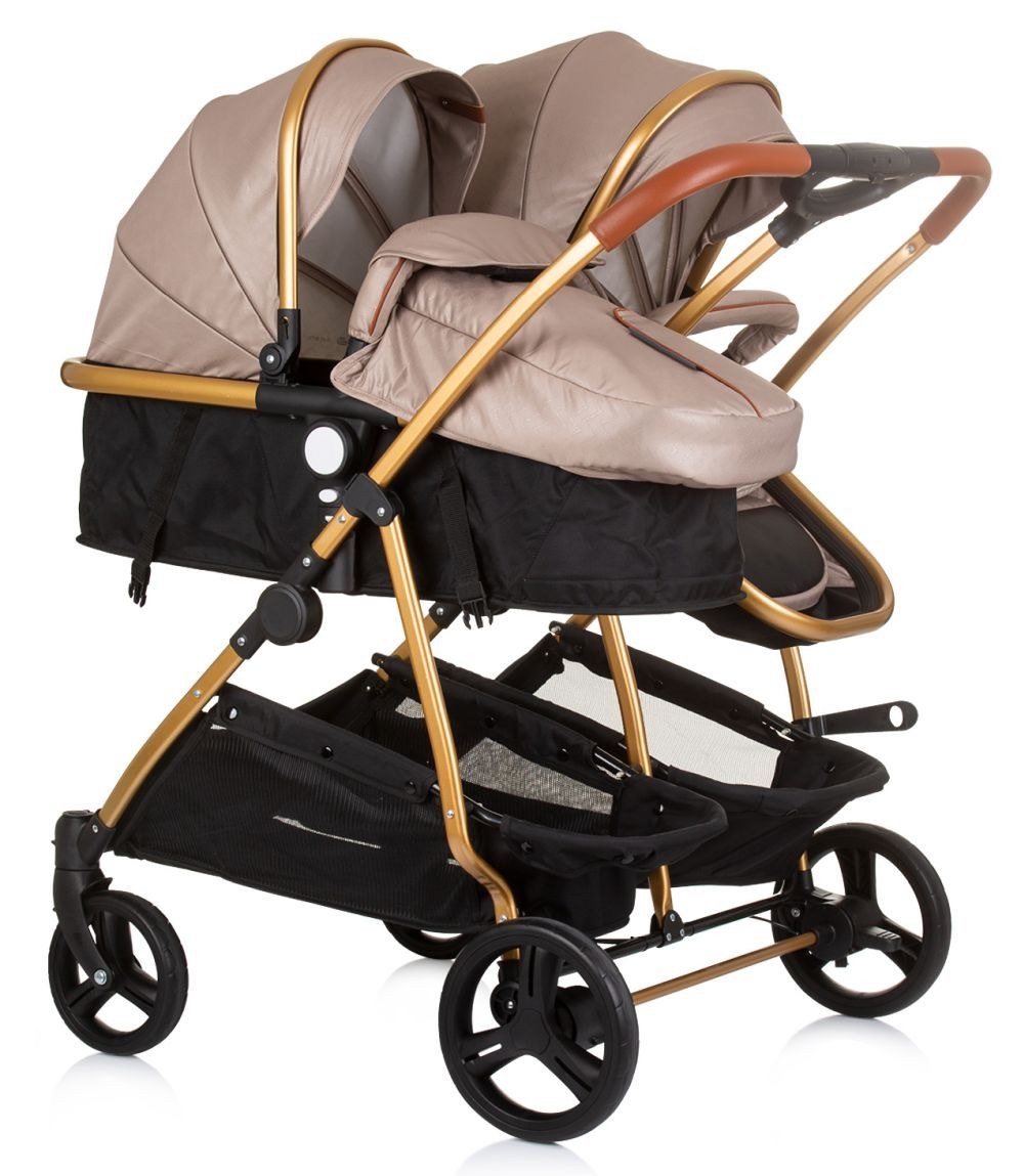 Doppelkinderwagen mit beigem und goldenem Rahmen. Zwei Sitze mit rosa Bezügen und ein schwarzer Korb darunter.