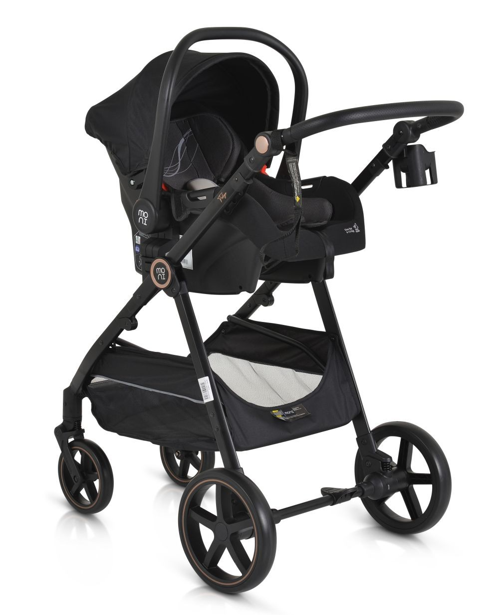 Cochecito de bebé negro con asiento de coche acoplado. Tiene cuatro ruedas y cesta.