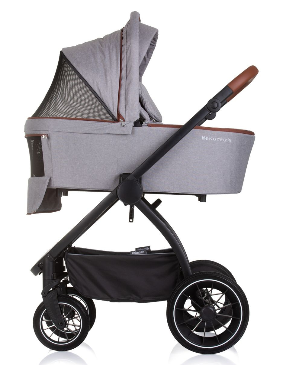 Grauer Kinderwagen mit Babywanne. Er hat eine Netzabdeckung. Der Rahmen ist schwarz, die Räder auch.
