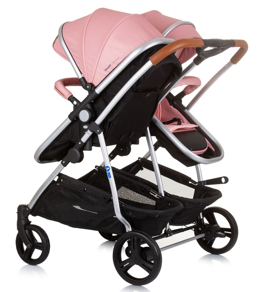 Ein rosa Zwillingskinderwagen mit schwarzem Rahmen. Er hat einen Ablagekorb.
