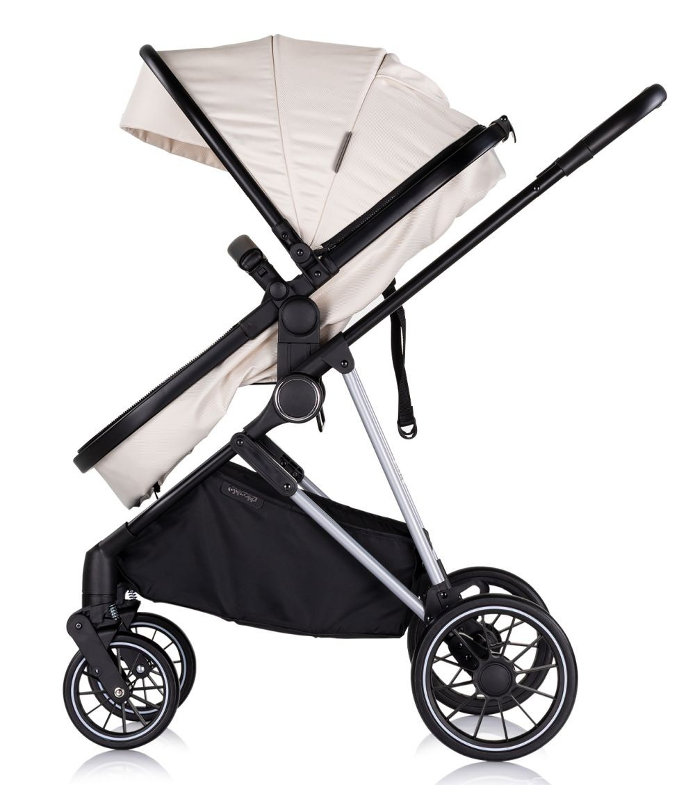 Elfenbeinfarbener Kinderwagen. Mit schwarzem Rahmen, schwarzen Rädern und Korb.