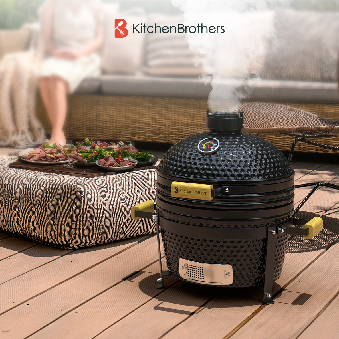 Grill kamado noir avec effet de fumée sur une terrasse en bois, avec nourriture et une personne.