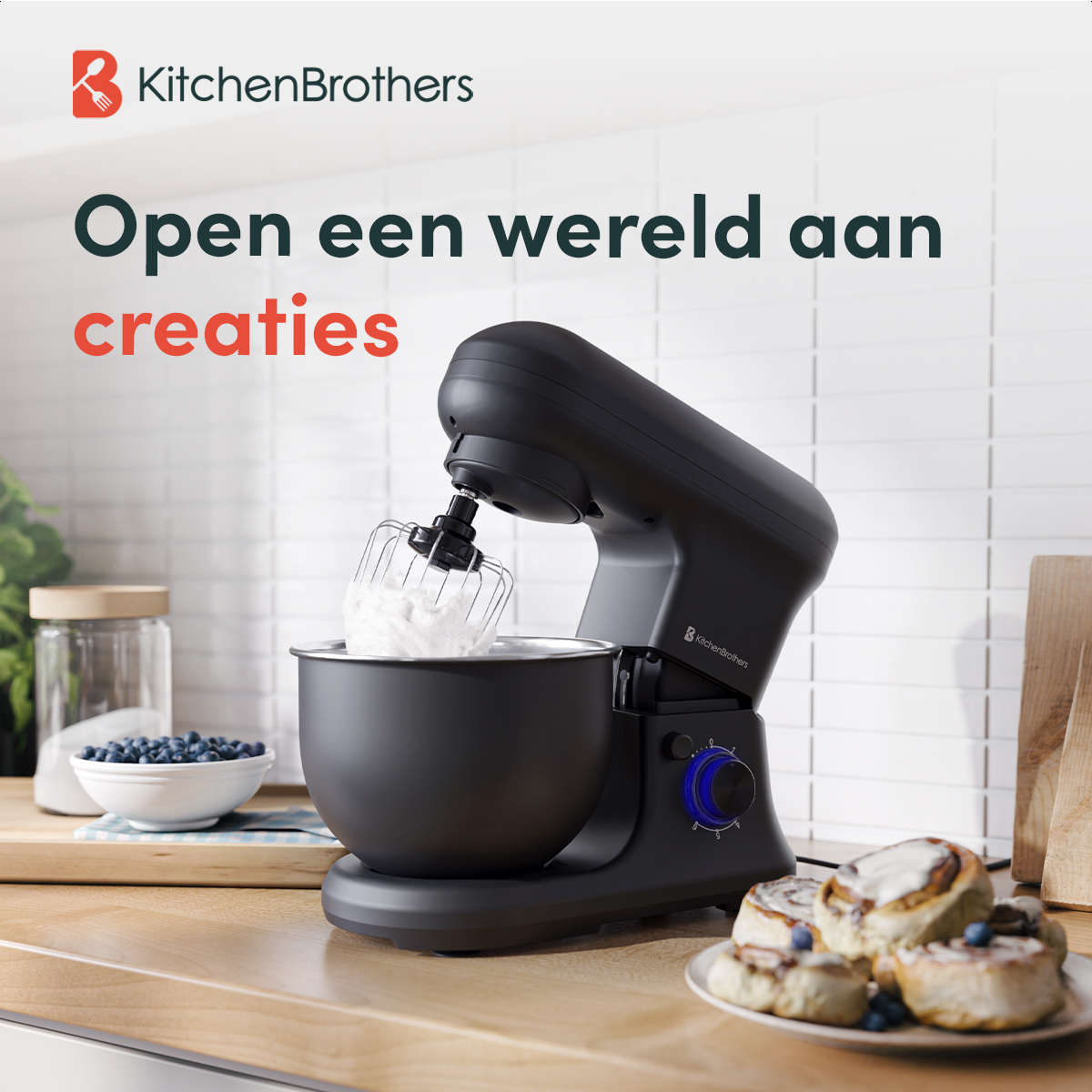 Zwarte keukenmixer met kom slagroom. Bord kaneelbroodjes rechts.