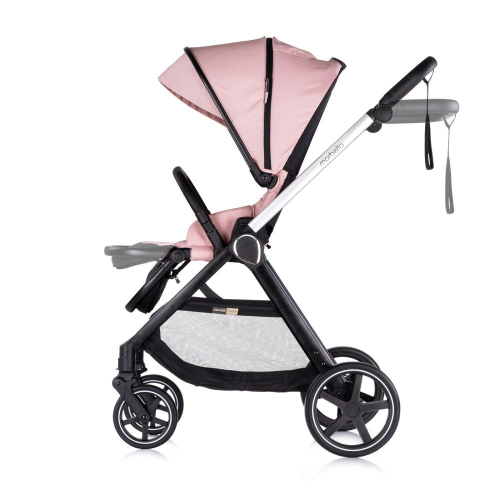 Rosa Kinderwagen, Seitenansicht, schwarzer Rahmen, vier Räder, Sonnenblende hoch. Weißer Hintergrund.