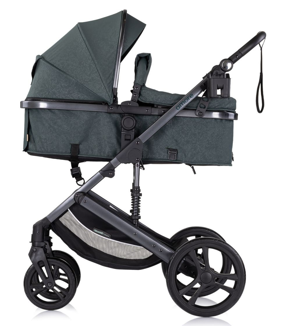 Ein dunkelgrüner Kinderwagen, Seitenansicht, schwarzer Rahmen, vier Räder, Sonnenblende hoch. Weißer Hintergrund.
