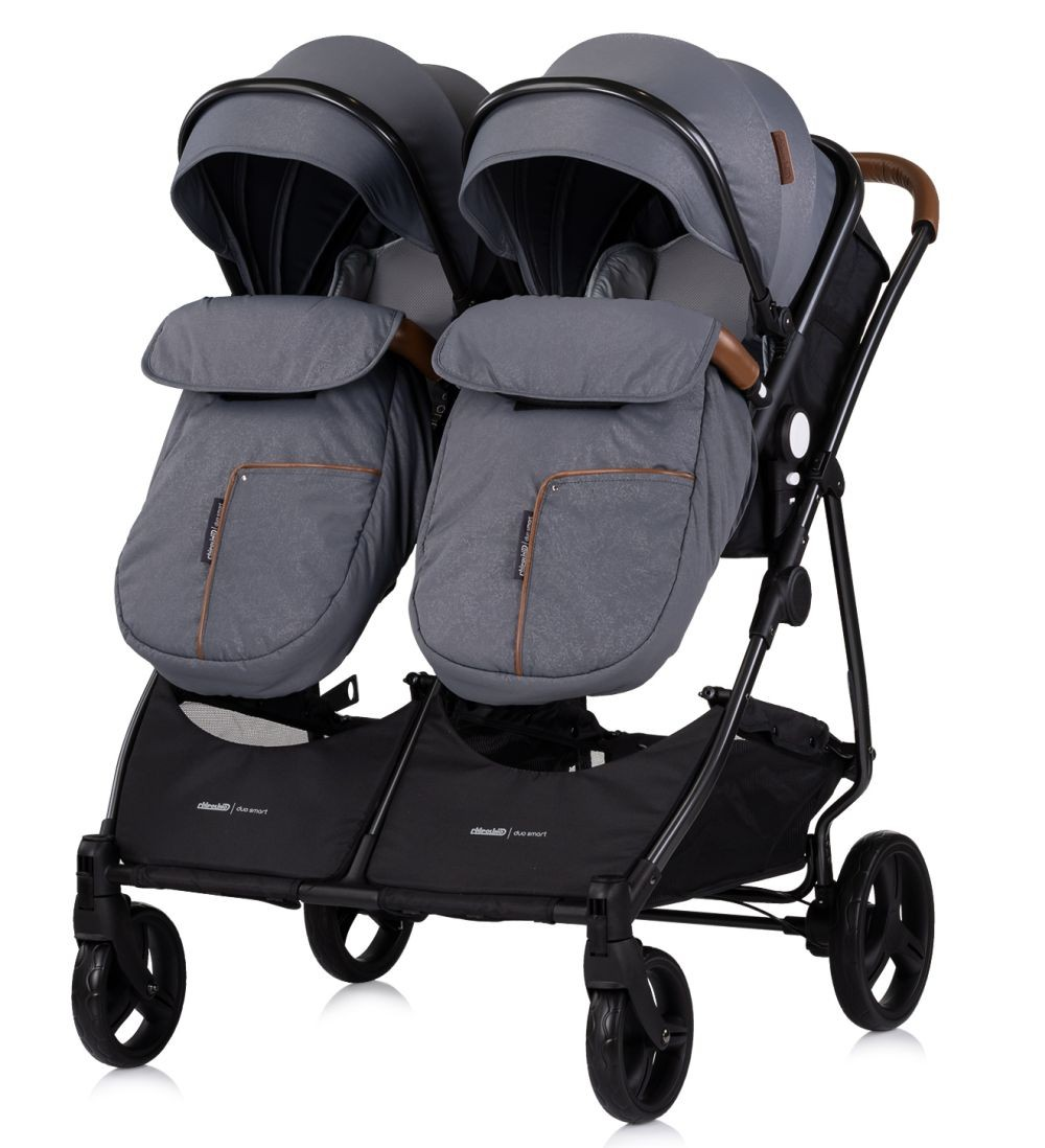Grauer Doppelkinderwagen mit grauen Verdecken, Seitenansicht.