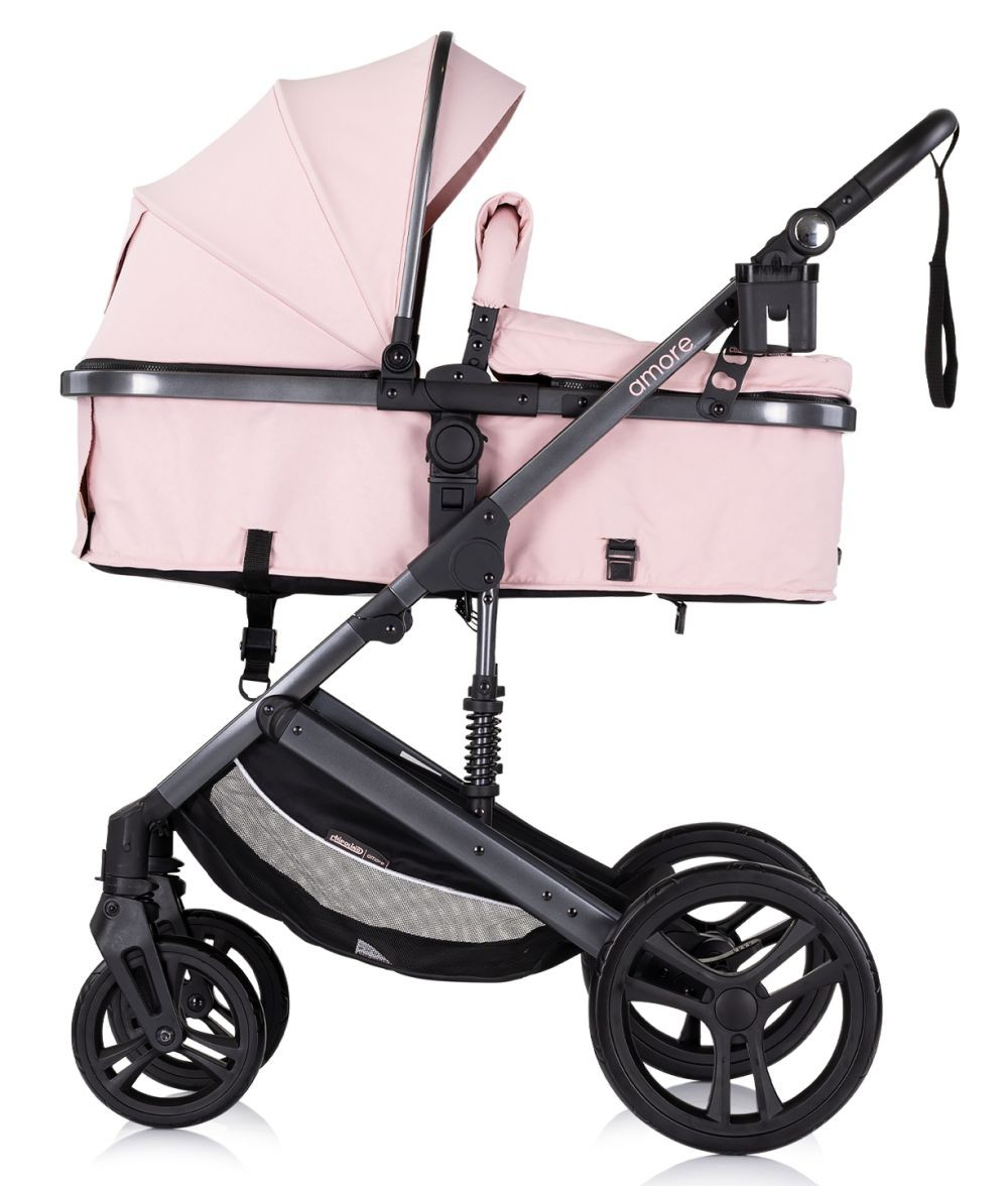 Rosa Kinderwagen mit schwarzem Rahmen und Rädern. Mit Babywanne. Weißer Hintergrund.