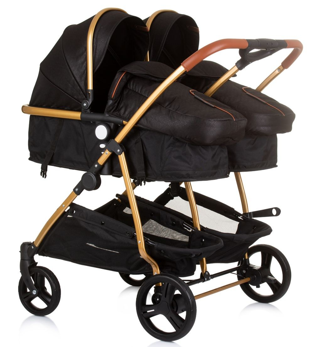 Doppelkinderwagen, schwarz mit goldenen Akzenten. Er hat zwei Sitze und zwei Körbe, mit braunen Ledergriffen.
