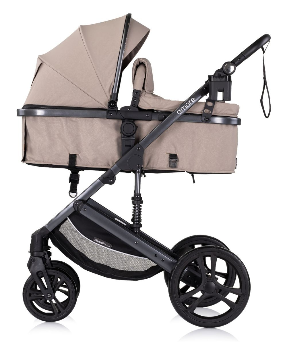 Beiger Kinderwagen mit Babywanne und schwarzen Akzenten. Mit Verdeck und Aufbewahrungskorb. Weißer Hintergrund.