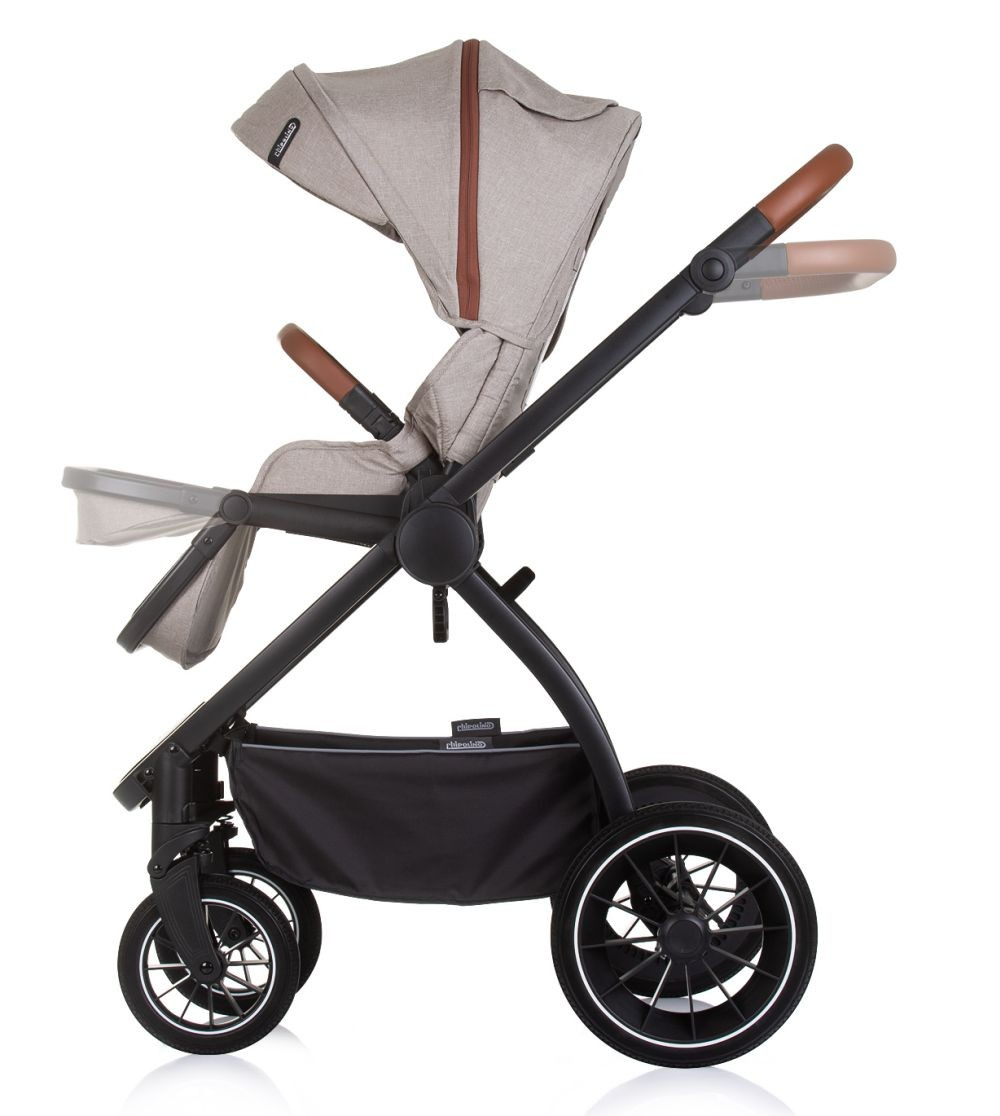 Kinderwagen Seitenansicht. Beiges Verdeck, schwarzer Rahmen, braune Griffe. Vier Räder. Weißer Hintergrund.