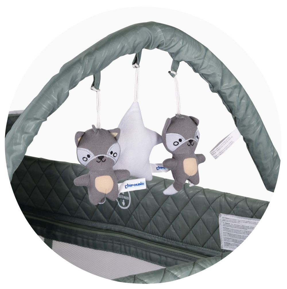 Babybett-Mobile mit zwei Waschbär-Spielzeugen und einem Stern. Vor grünem, gestepptem Hintergrund.