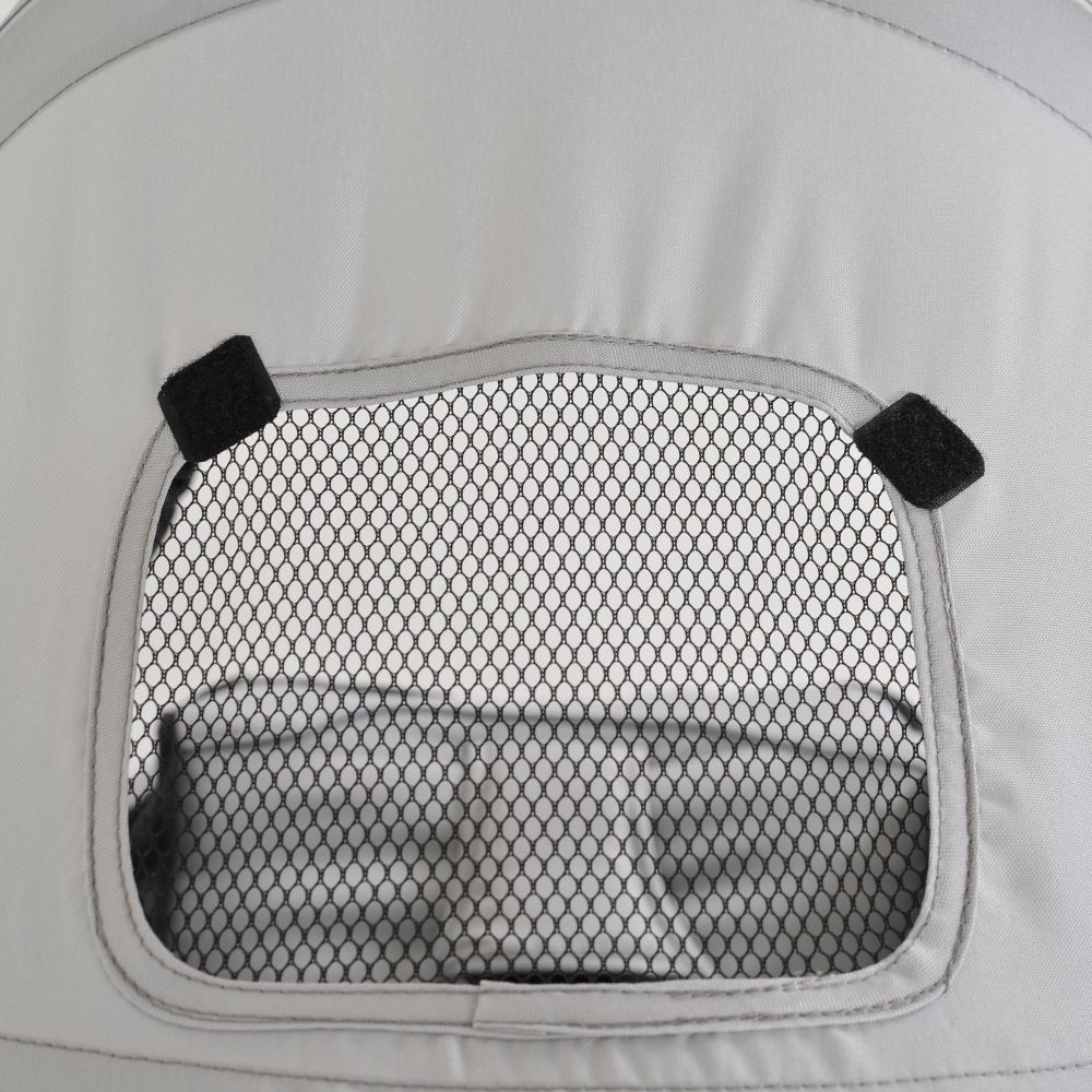 Nahaufnahme des Kinderwagen-Sonnenschutzfensters mit Netz und Klettverschlüssen.