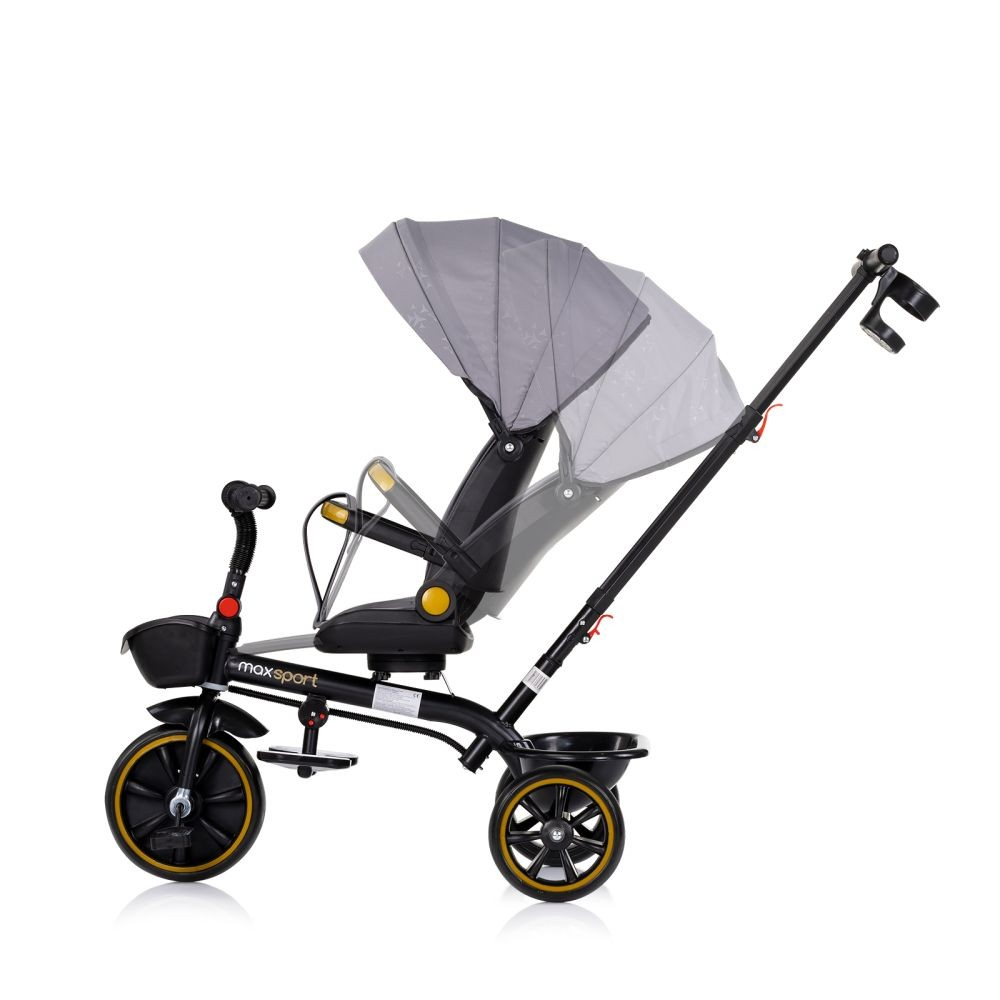 Triciclo gris con marco negro. Tiene parasol y manillar parental. Fondo blanco.