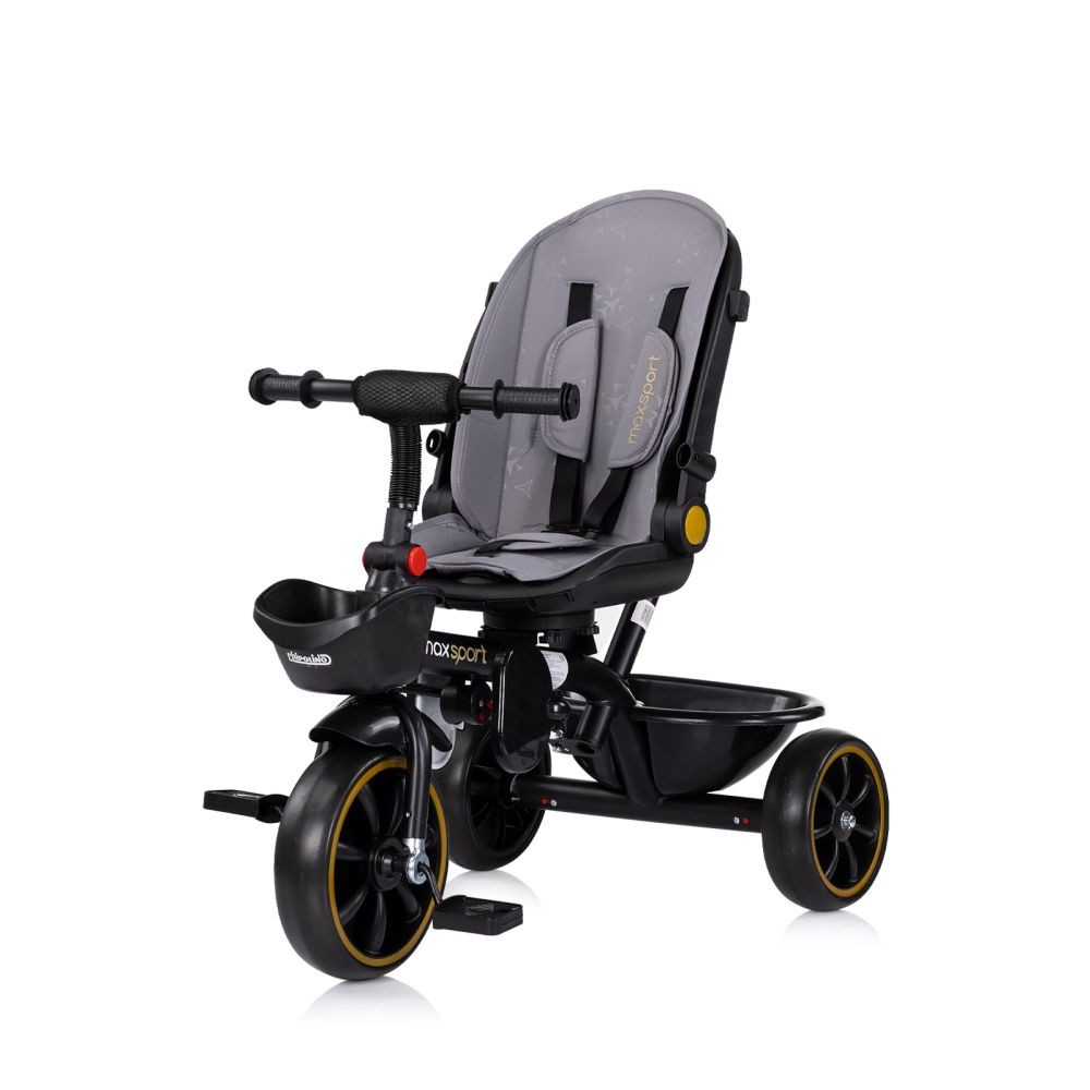 Triciclo para bebé negro y gris con detalles dorados. Tiene parasol y cesta.