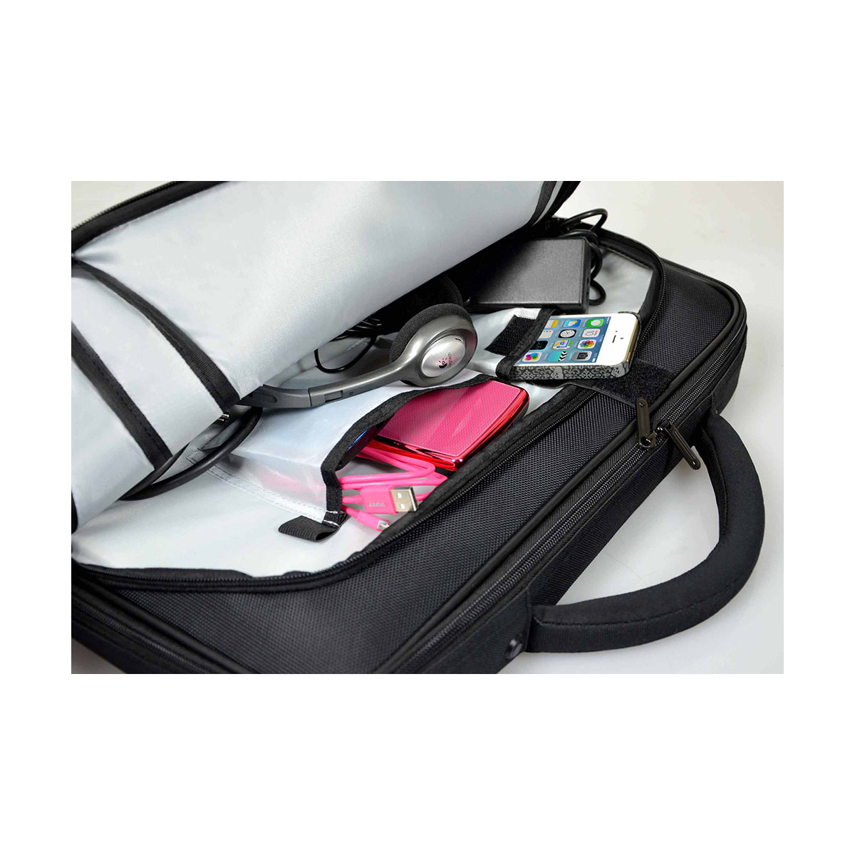 Open zwarte laptoptas gevuld met items, waaronder een koptelefoon en een roze apparaat.