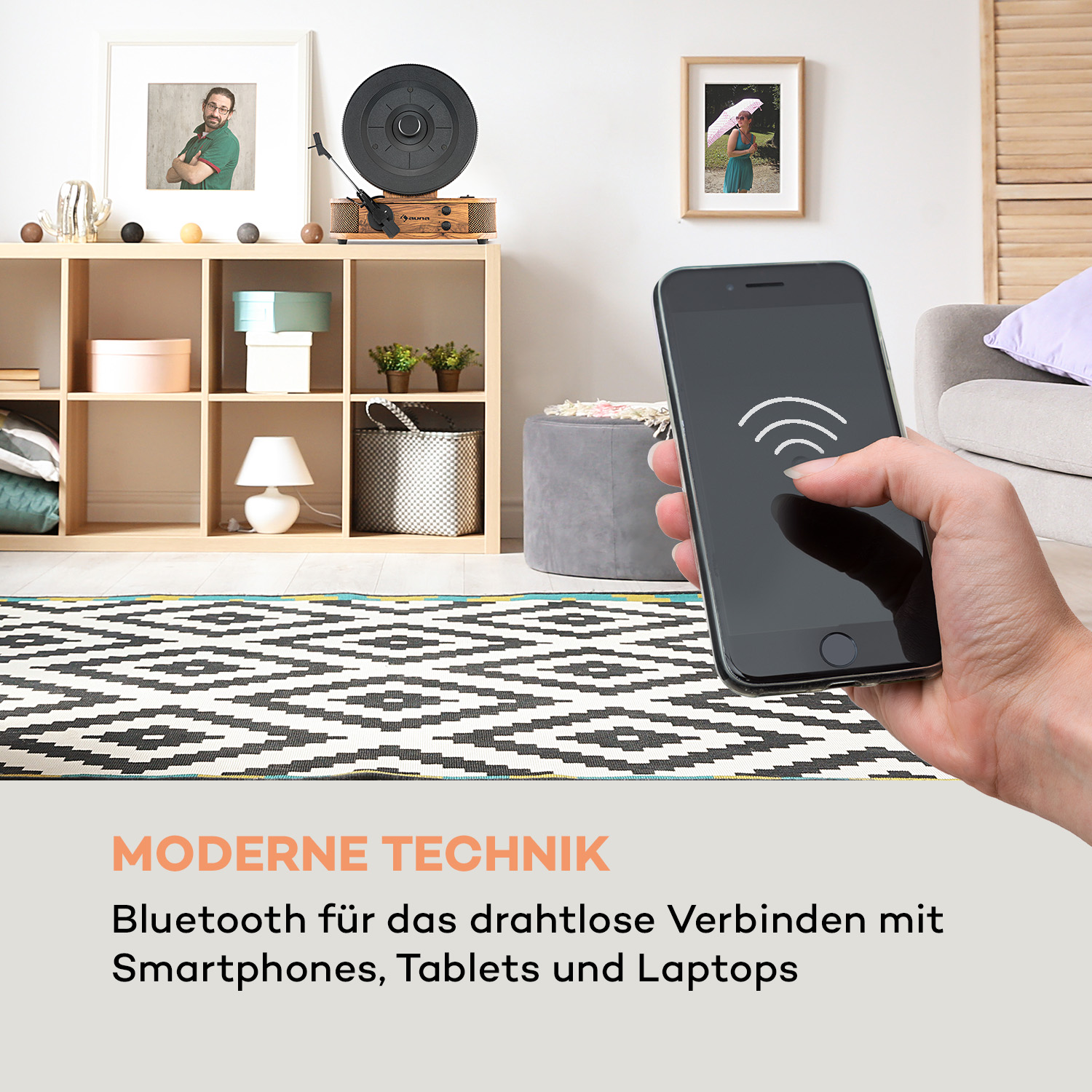 Eine Hand hält ein Smartphone mit einem modernen Wohnzimmer im Hintergrund. Ein Teppich ist darunter.