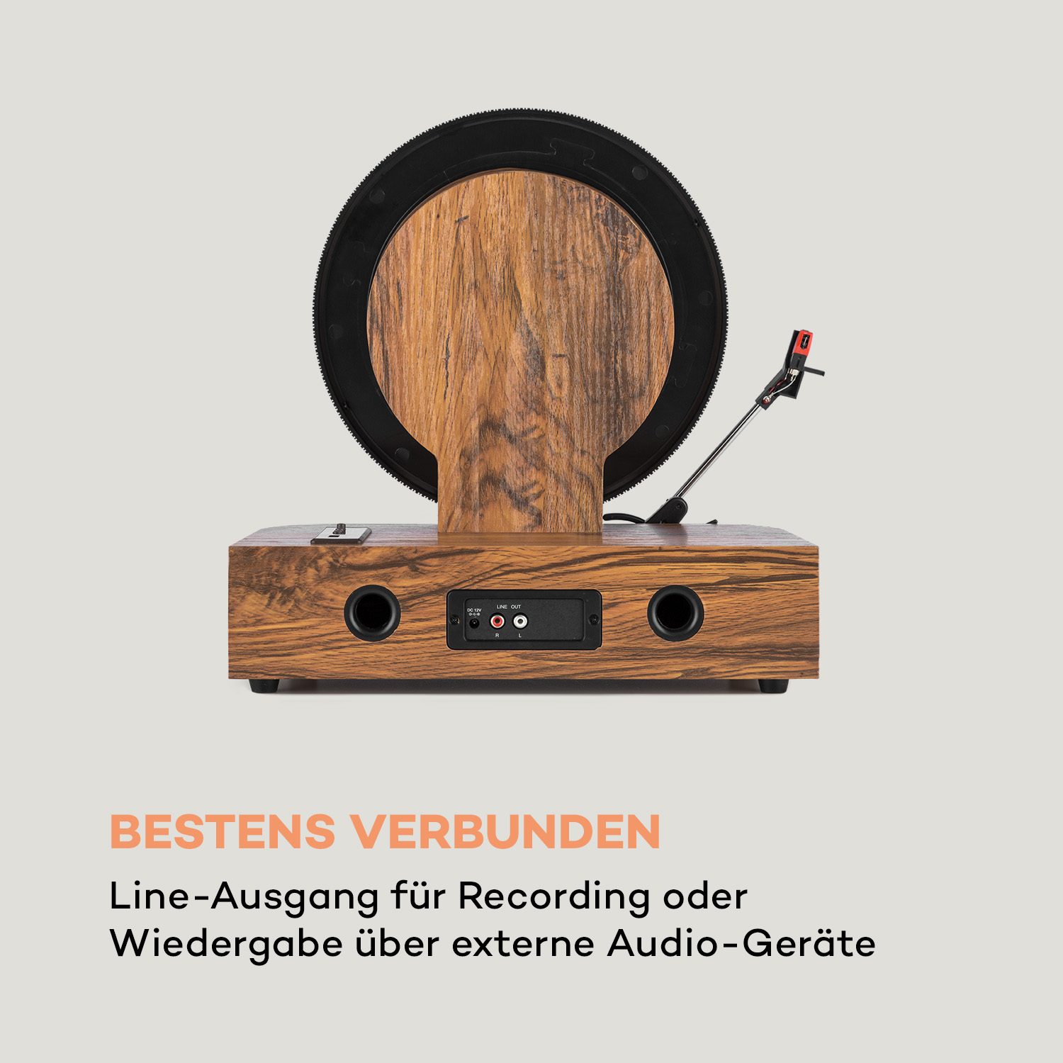 Plattenspieler aus Holz mit schwarzer Scheibe und Tonarm. Line-Out-Anschlüsse sichtbar.