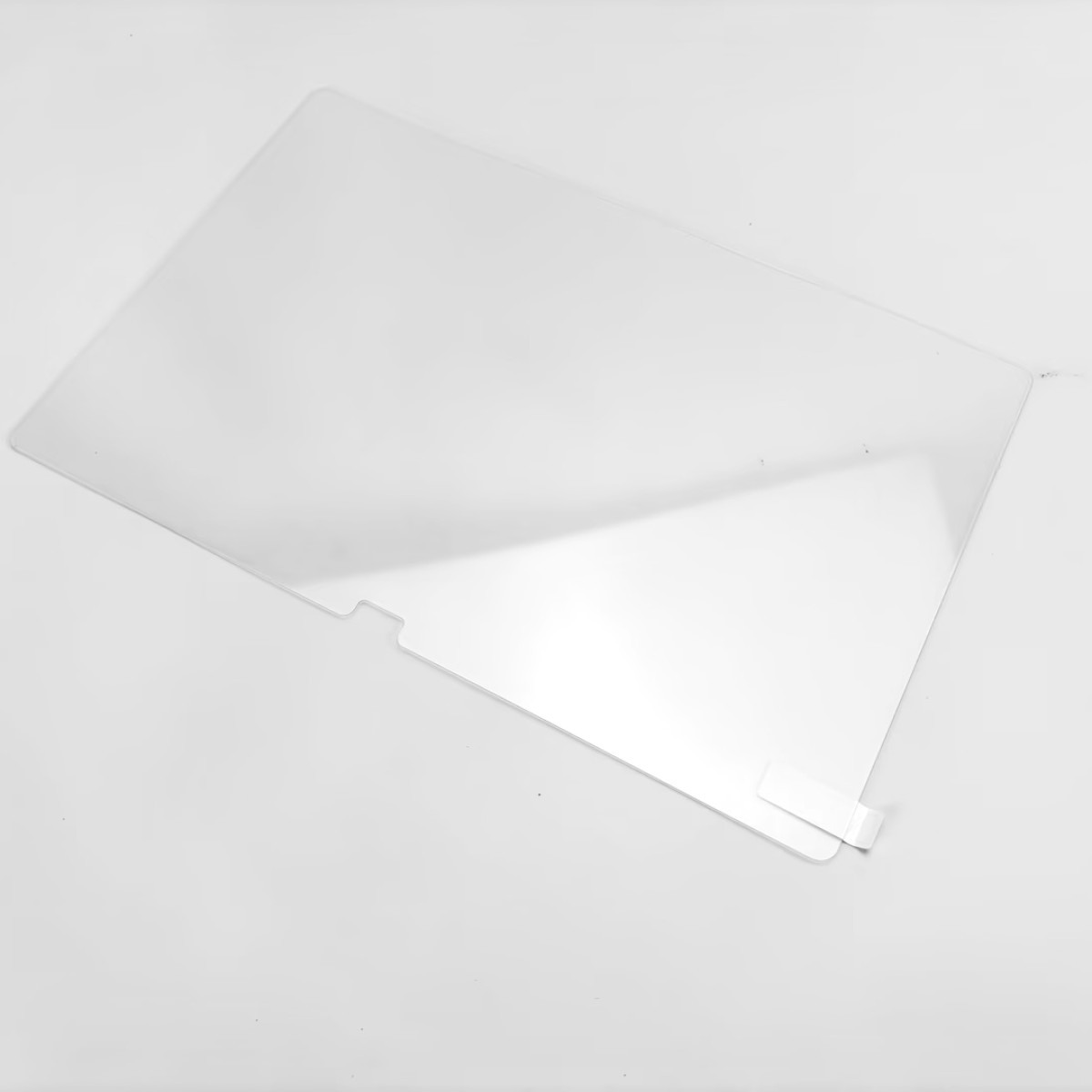 Een heldere, rechthoekige schermbeschermer op een wit oppervlak, licht gekanteld. Kleine witte lip.
