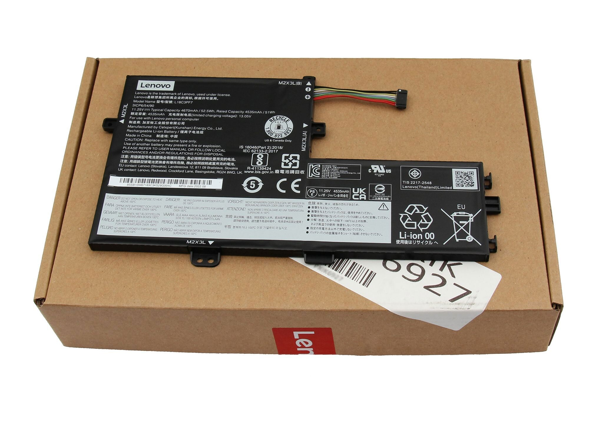 Zwei schwarze Laptop-Akkus auf einem Karton, mit Etiketten und Markierungen sichtbar.