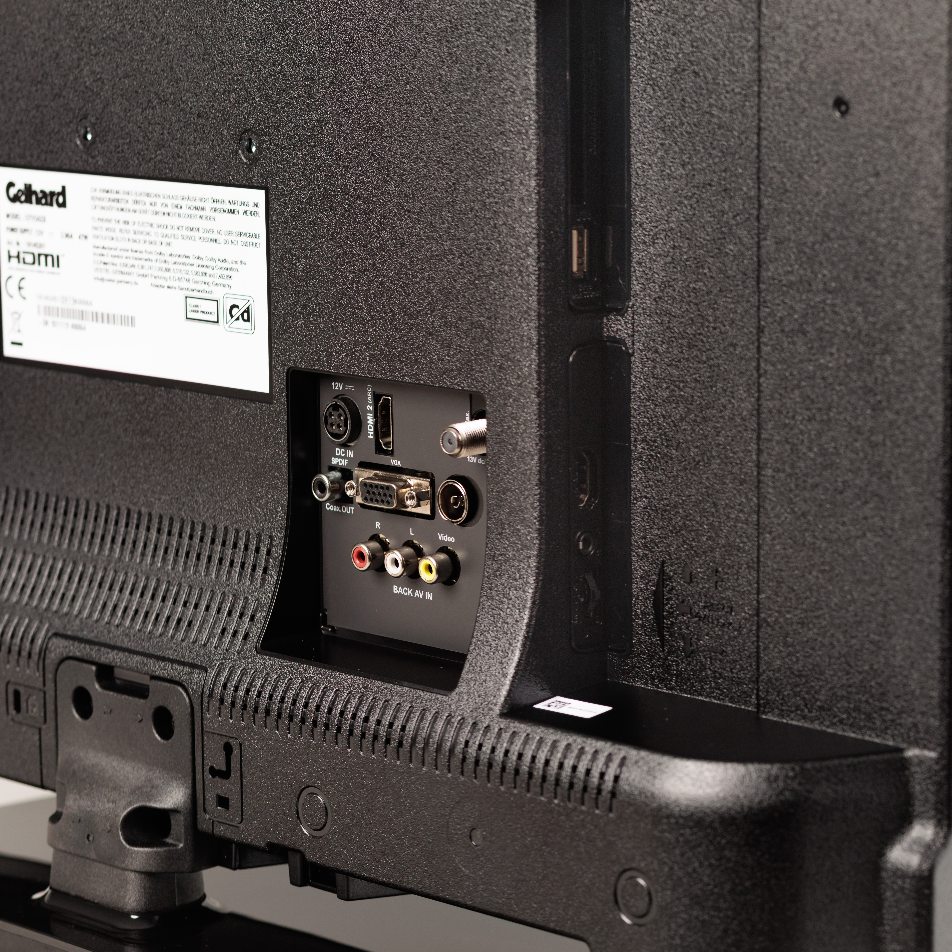 Nahaufnahme der Rückseite eines schwarzen Fernsehers mit verschiedenen Anschlüssen und Etiketten, HDMI-Anschlüsse sind sichtbar.