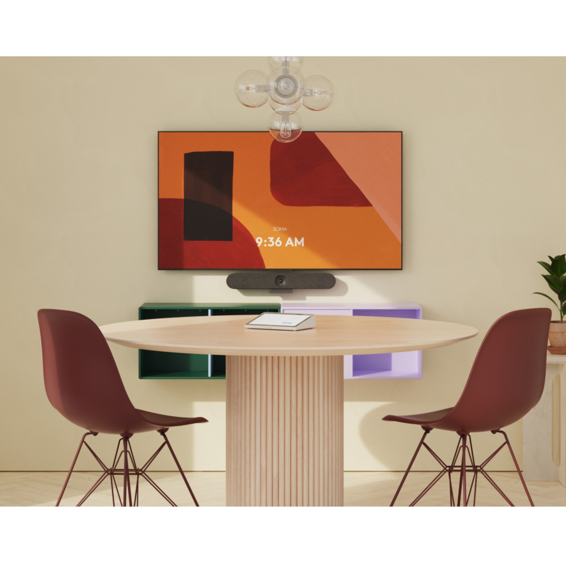 Besprechungsraum mit Fernseher, Soundbar, Tisch und Stühlen. Creme- und grüne Wände, neutraler Ton.