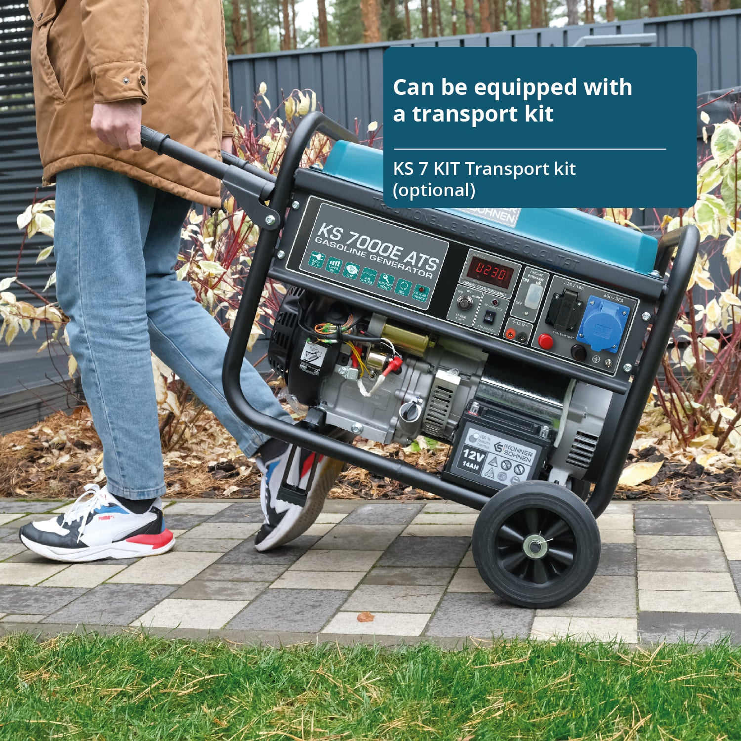 Mężczyzna pcha generator na zestawie transportowym. Generator stoi na kamiennej ścieżce z roślinami i płotem.