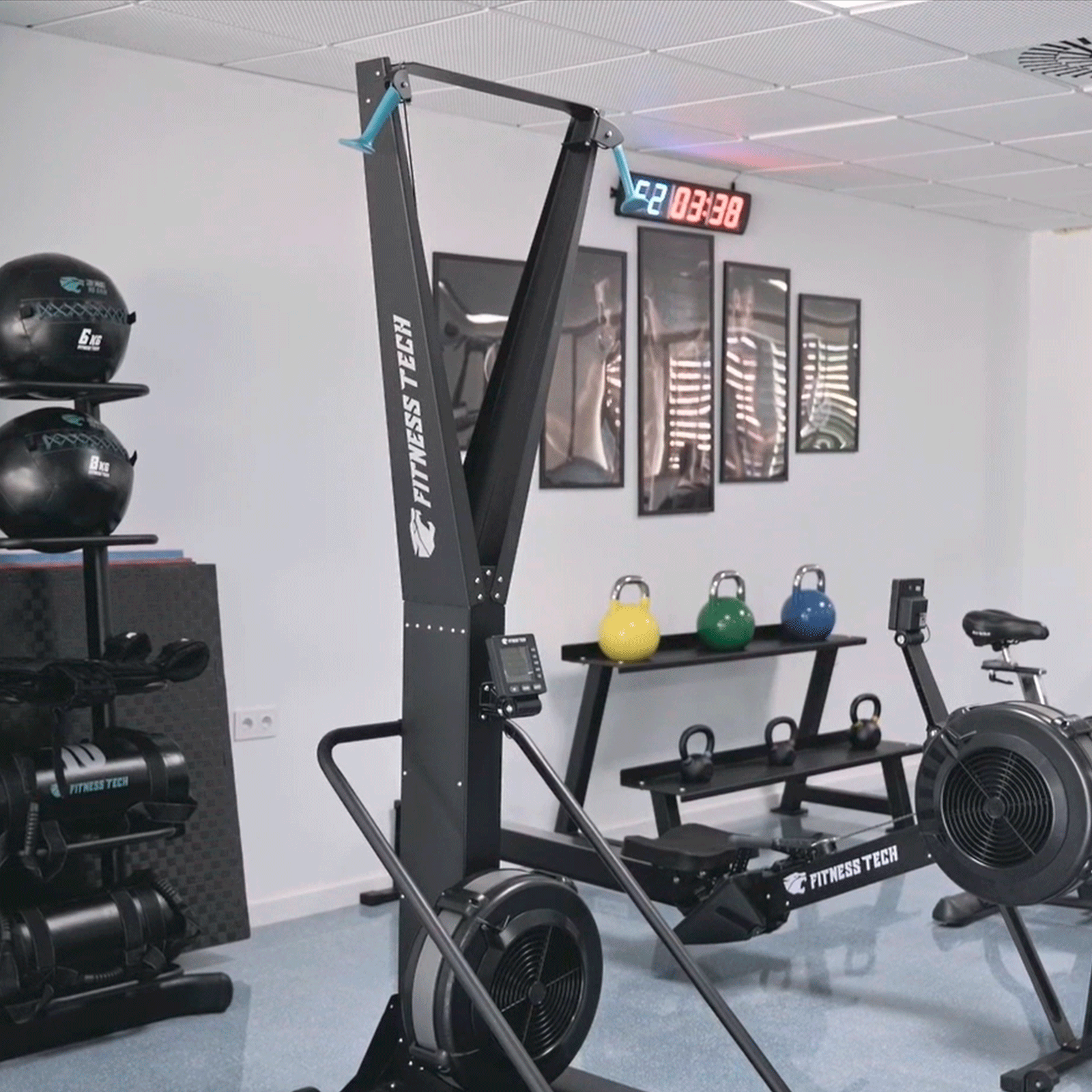 Gimnasio con equipo Fitness Tech. Máquina de fitness negra. Pesas rusas y reloj.