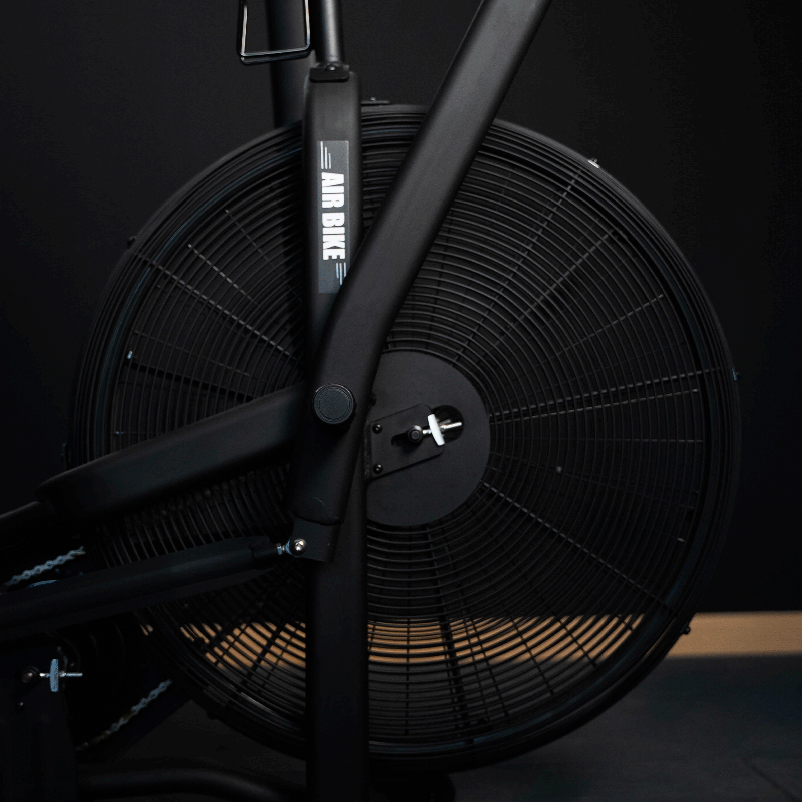 Primo piano della ventola di una air bike nera. La ventola è circolare e ha una cornice nera.