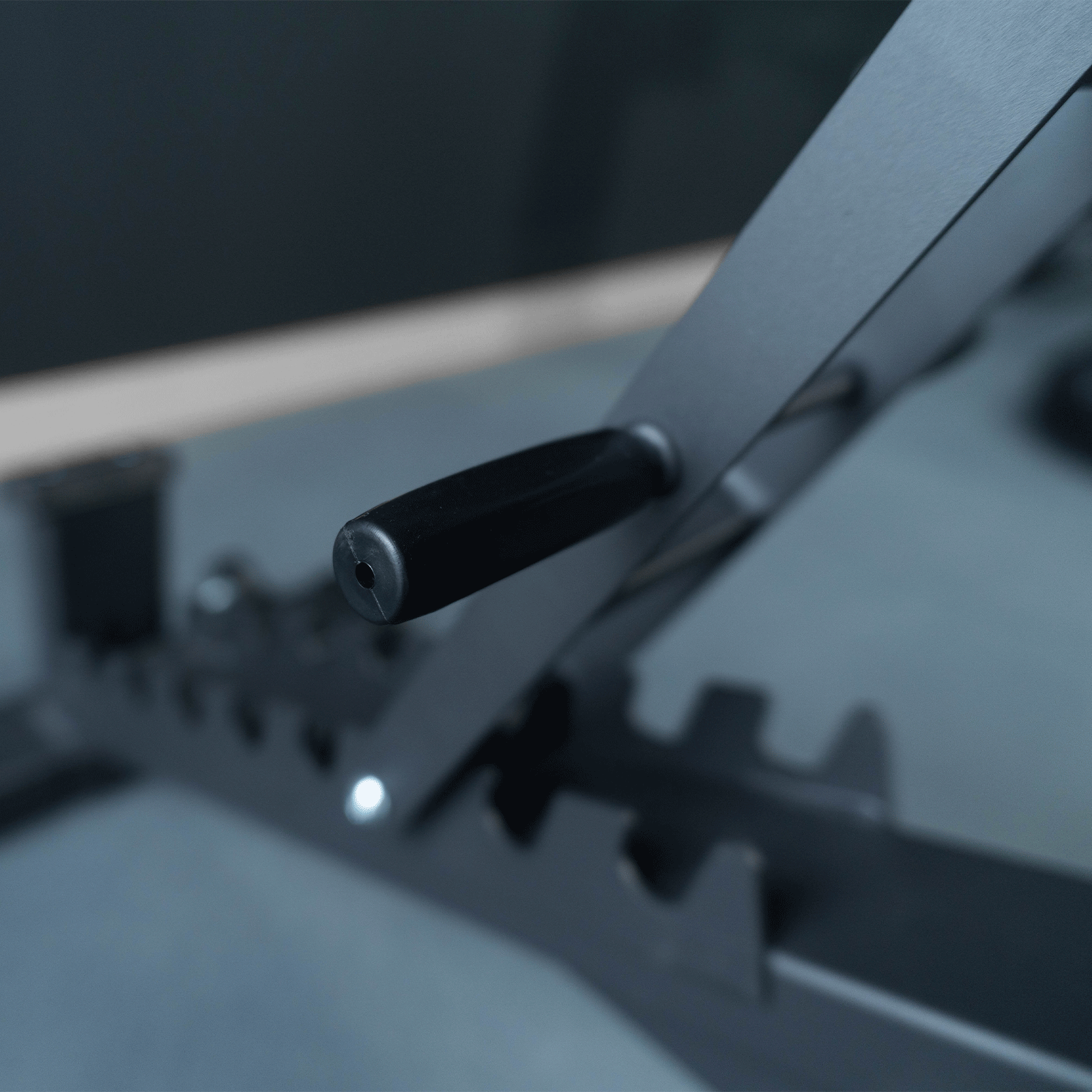 Primer plano de un asa negra en una máquina de gimnasio. Fondo negro. Toma de detalle.