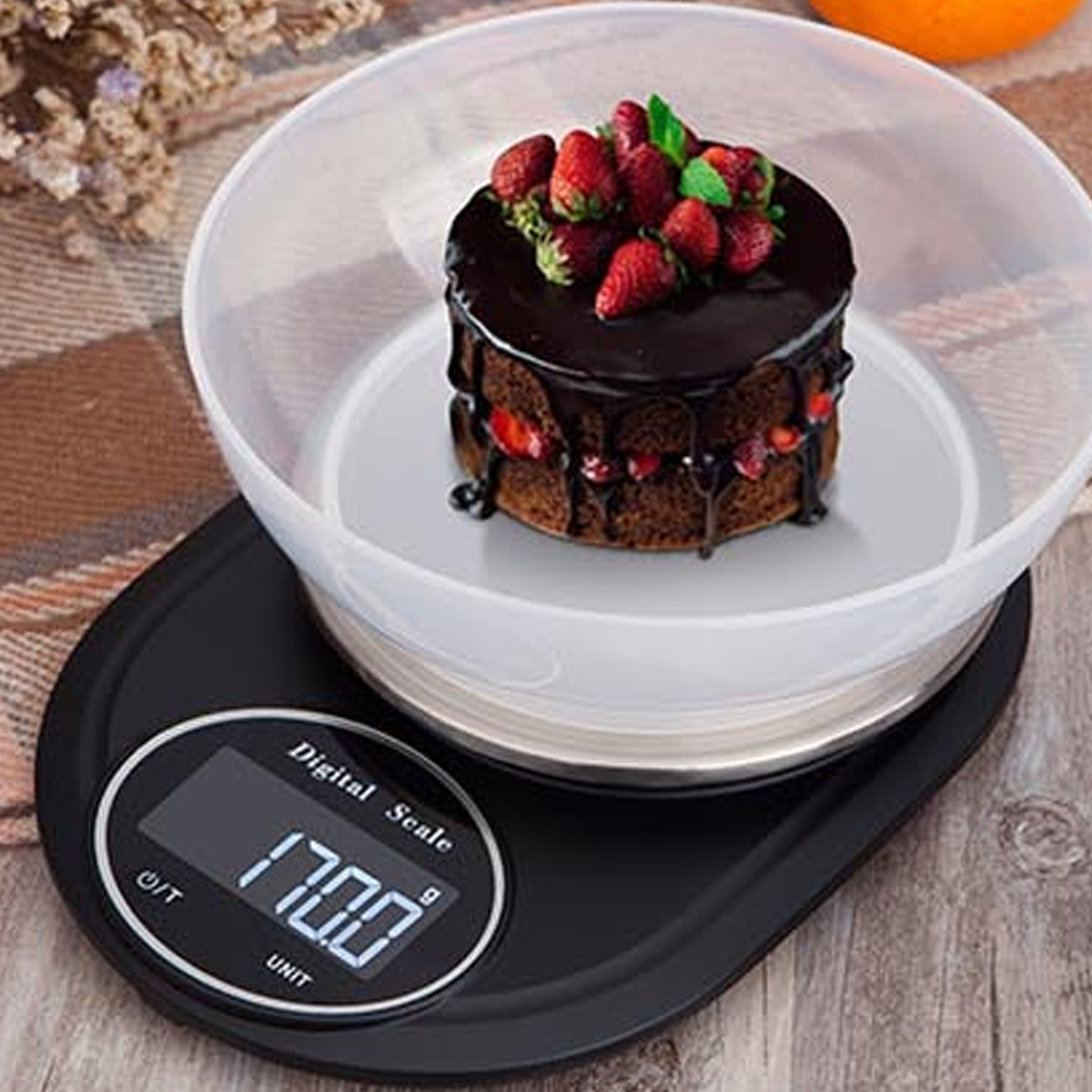 Ein Kuchen auf einer Waage. Die Waage zeigt 170,0 an. Der Kuchen hat Schokolade und Erdbeeren.