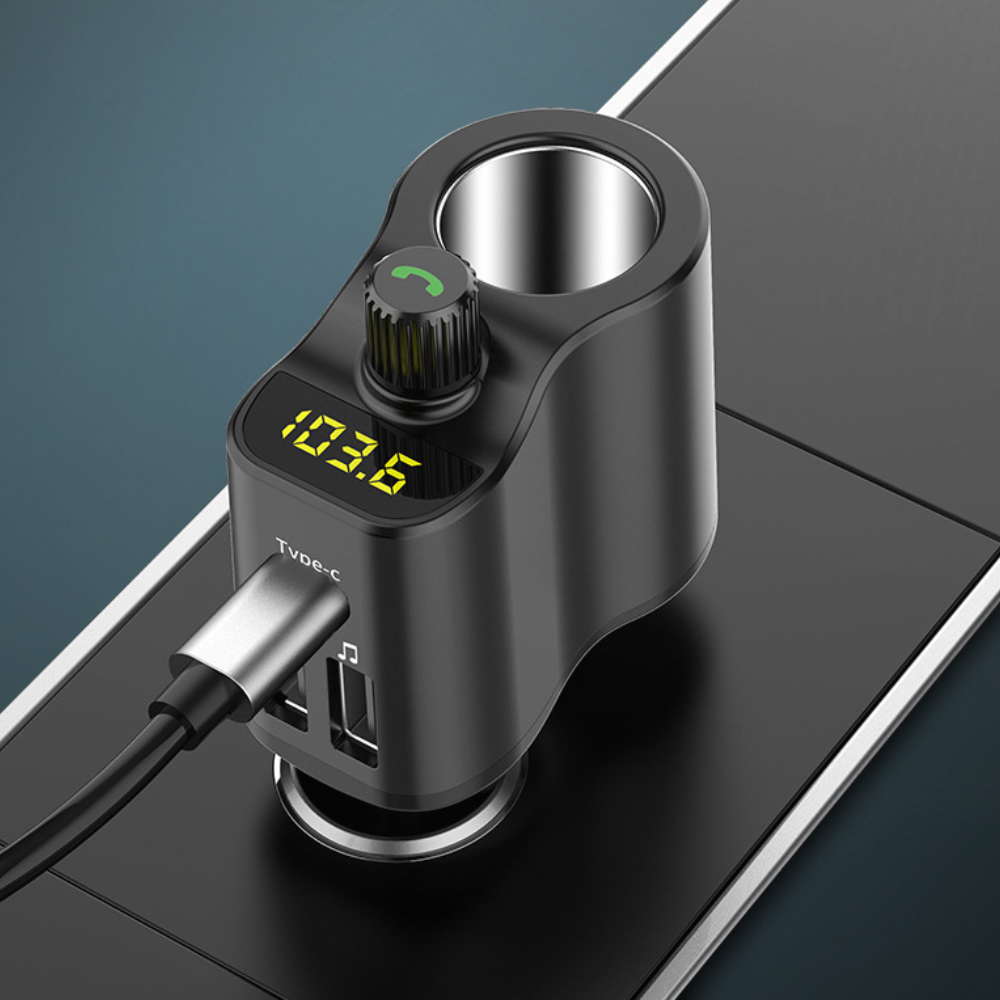Schwarzes Autoladegerät mit Anzeige 103,6, eingesteckt in eine schwarze Oberfläche. USB- und Typ-C-Anschlüsse sichtbar.