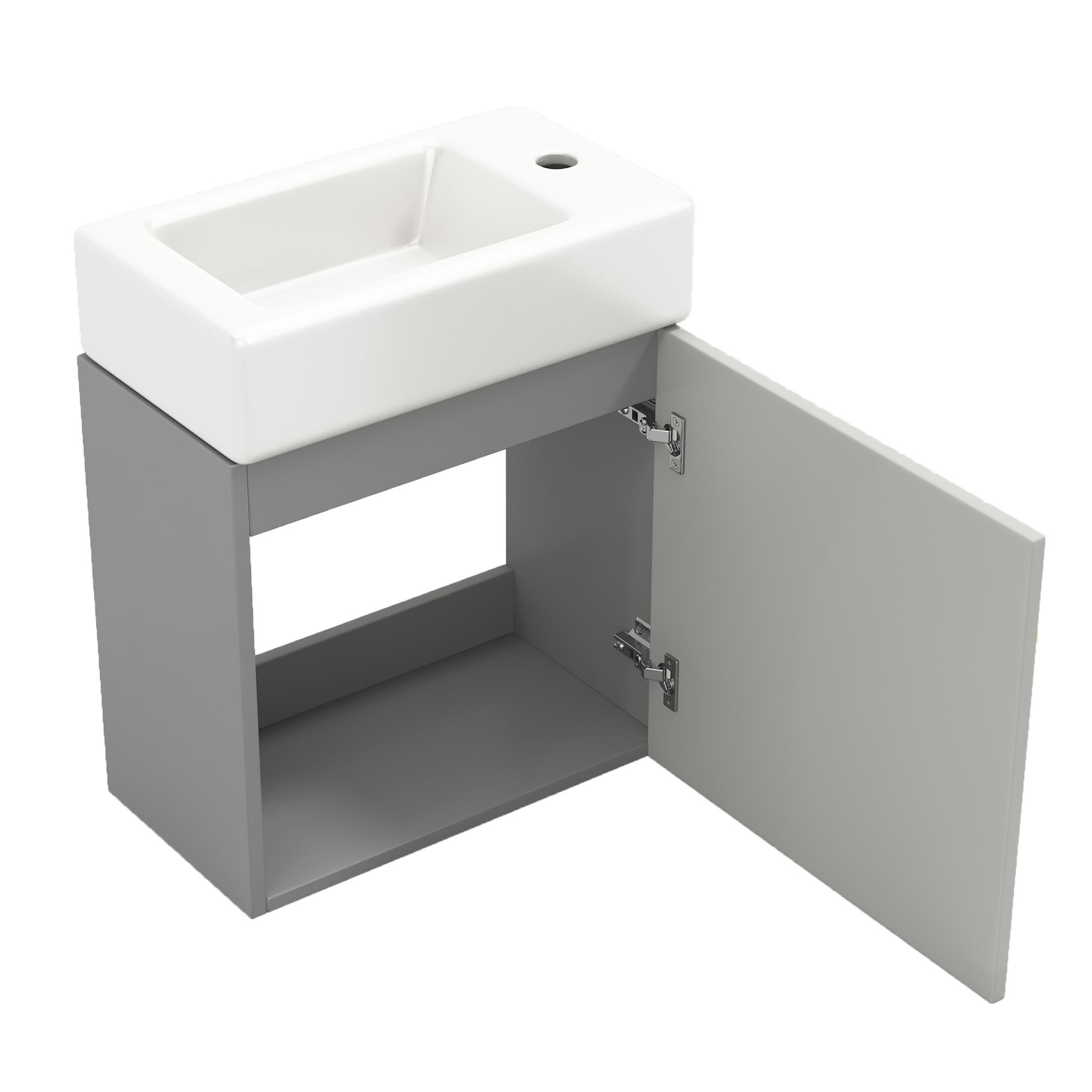 Badezimmer-Waschtisch mit offener Tür. Weißes Waschbecken, grauer Schrank und Scharniere sind sichtbar.