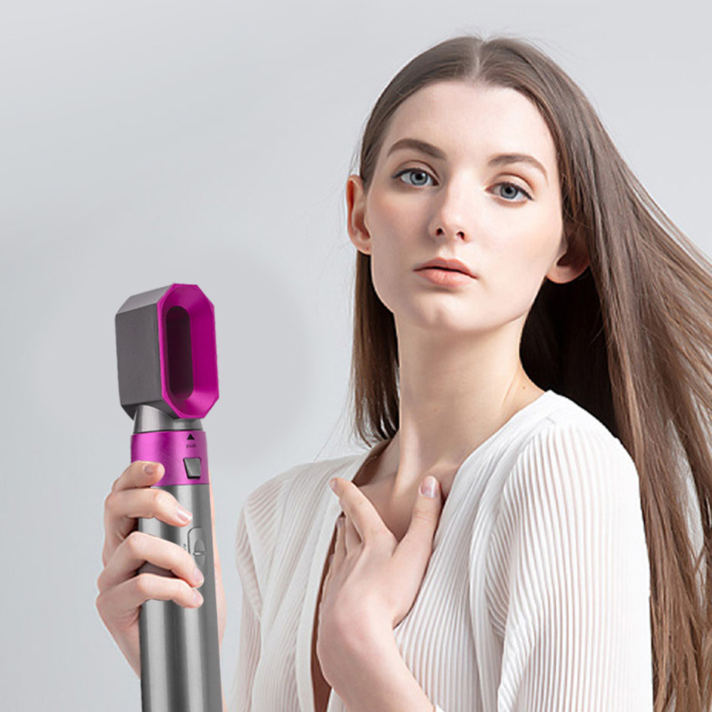 Eine Frau hält ein Haarstyling-Werkzeug. Das Werkzeug ist silber und rosa.