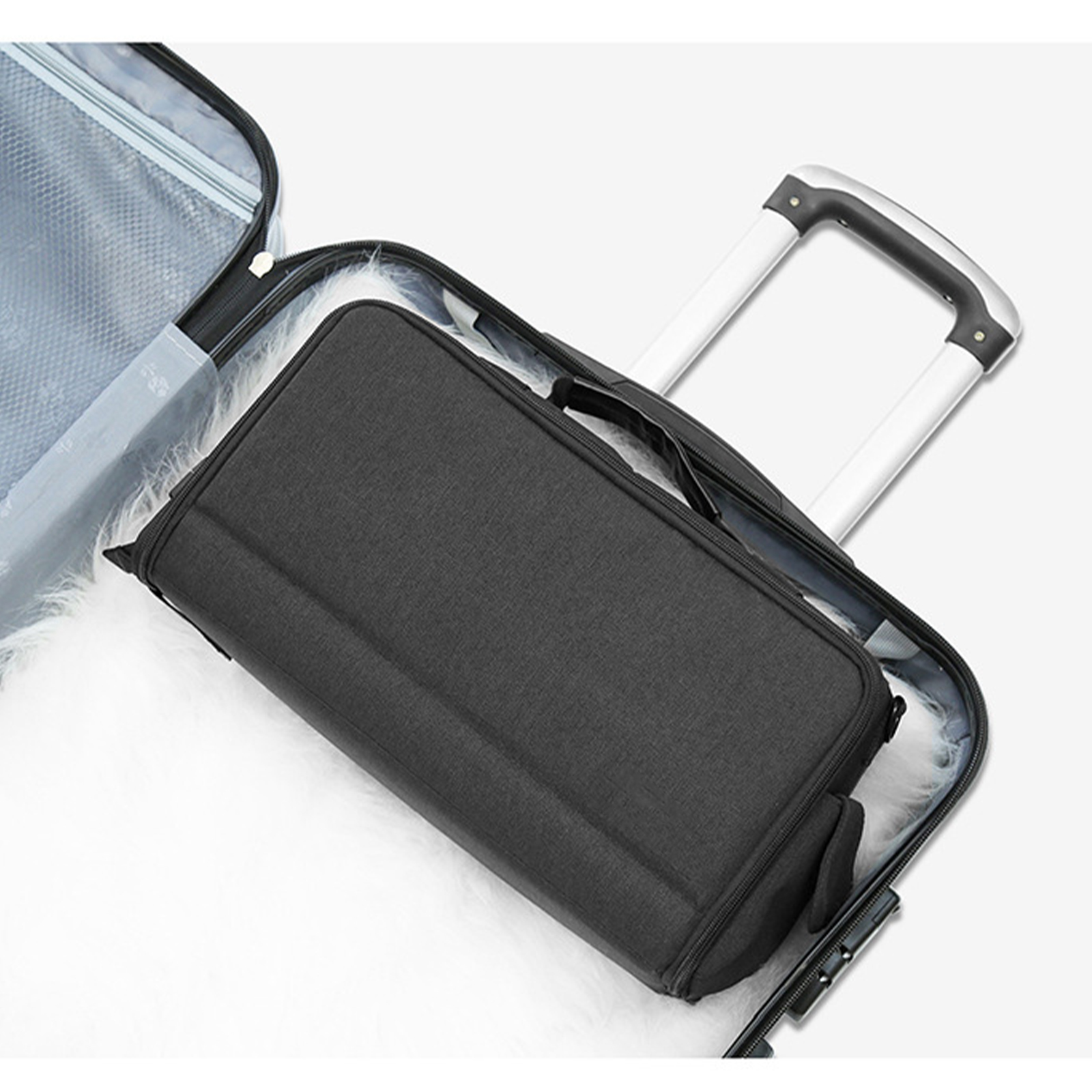 Eine schwarze Reisetasche befindet sich in einem Koffer. Der Koffer ist offen mit hochgestelltem Griff.