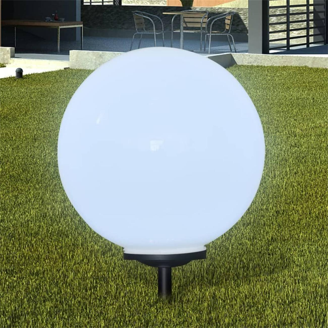 Eine weiße, kugelförmige Außenlampe auf einem schwarzen Ständer, auf grünem Gras platziert.