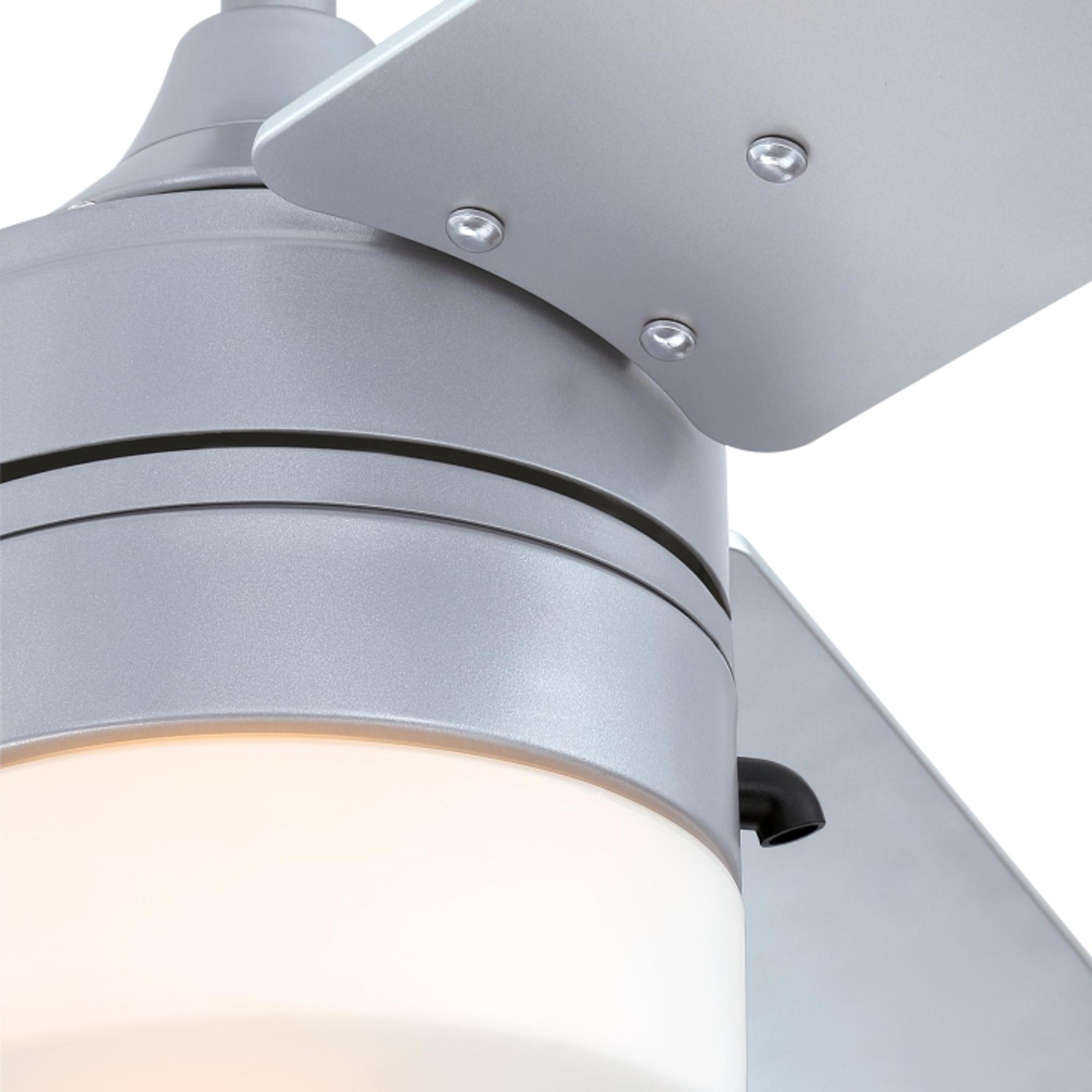 Nahaufnahme des Deckenventilators. Das Licht und ein Teil eines silbernen Flügels sind sichtbar.