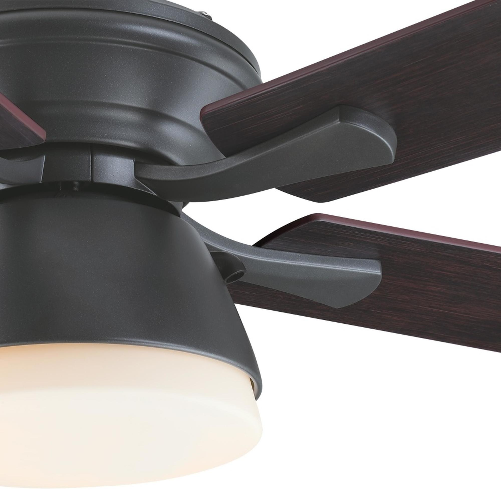 Nahaufnahme des Motors und der Flügel eines Deckenventilators. Die Flügel sind aus dunklem Holz, der Motor ist dunkelgrau.